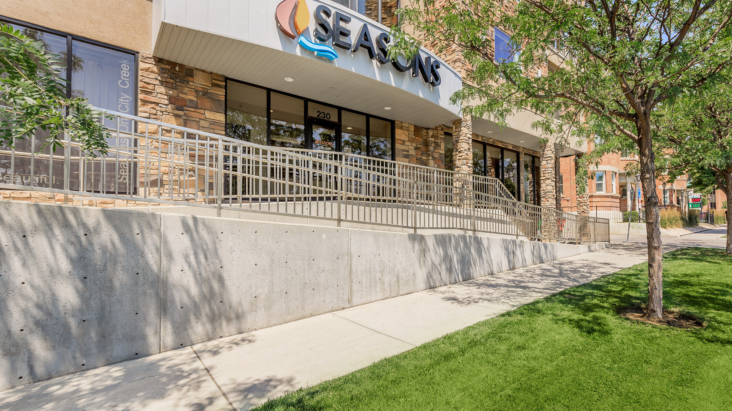 Inviting apartment building exterior featuring modern architecture, lush green lawns, and a welcoming entryway.
