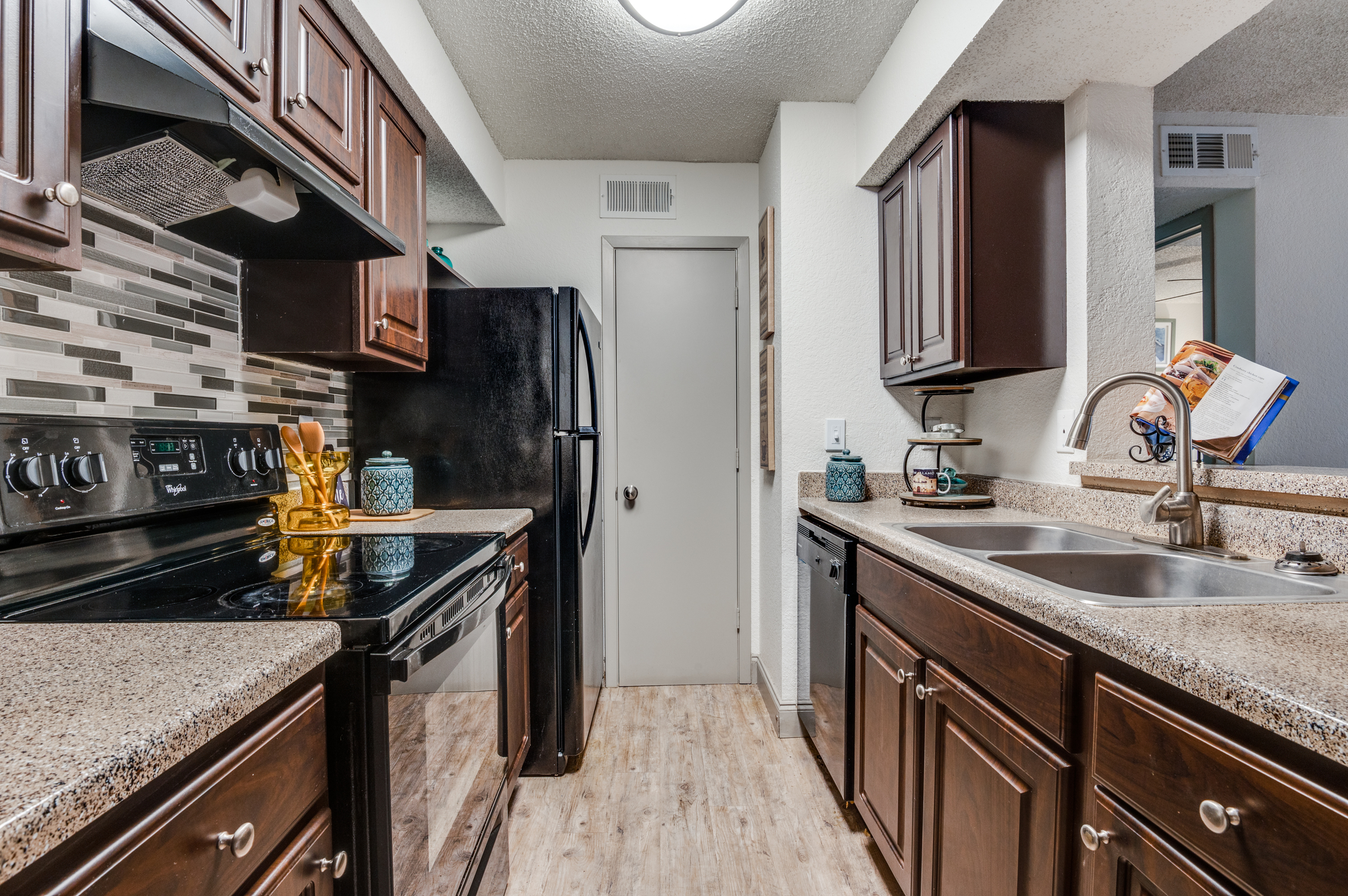 Modern kitchen boasting elegant dark wood cabinetry, sleek countertops, and stainless steel appliances, perfect for culinary enthusiasts.