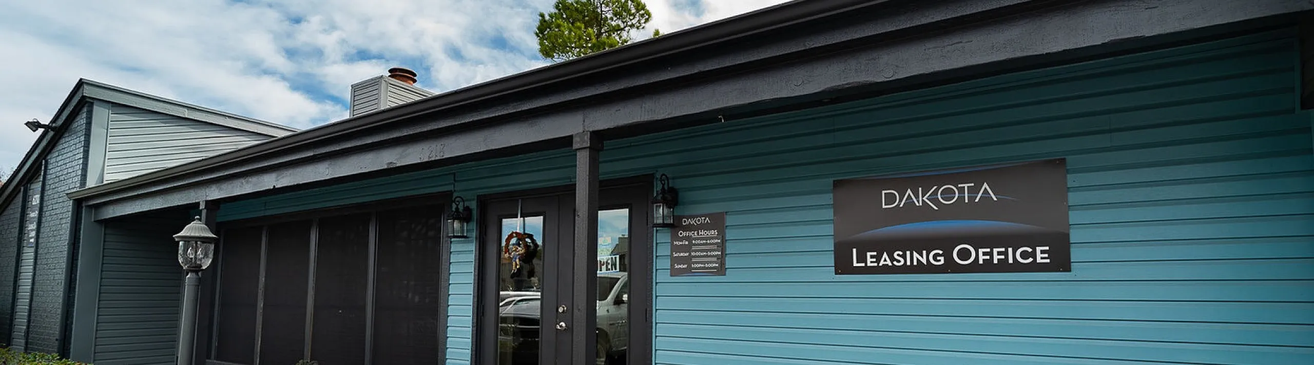 Welcoming exterior of Dakota Leasing Office with modern design and vibrant blue siding.