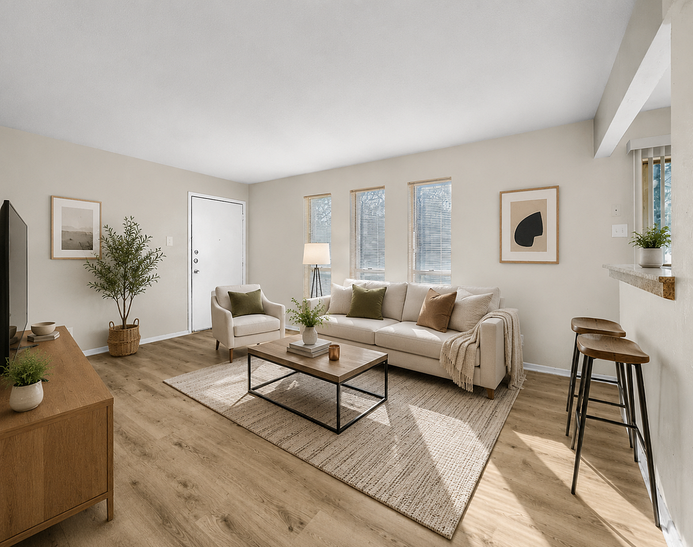 Elegant living room with natural light, featuring a cozy seating area, stylish decor, and modern wooden flooring.