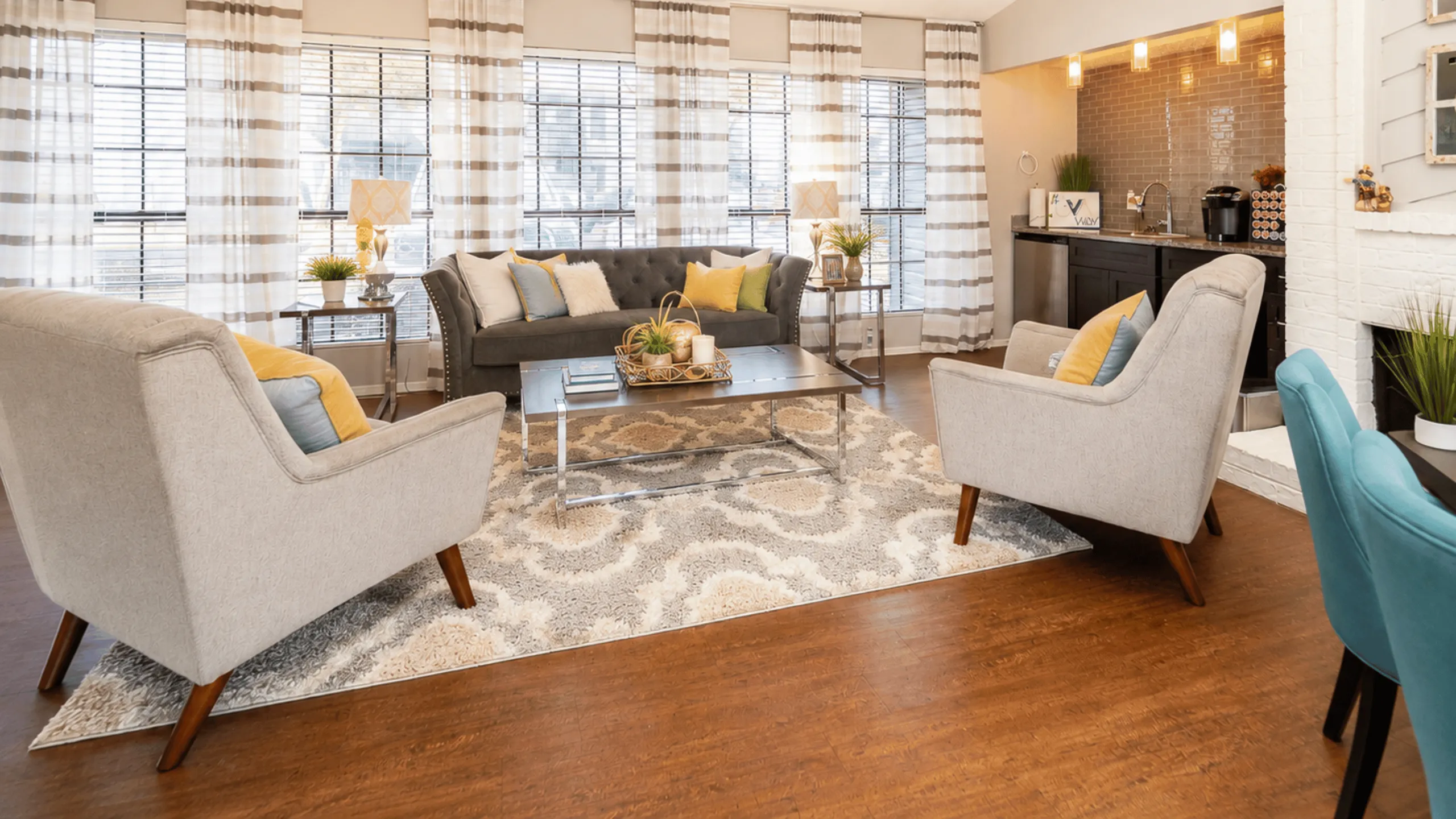 Bright and inviting living room with modern decor, featuring cozy seating, stylish coffee table, and warm hardwood flooring.