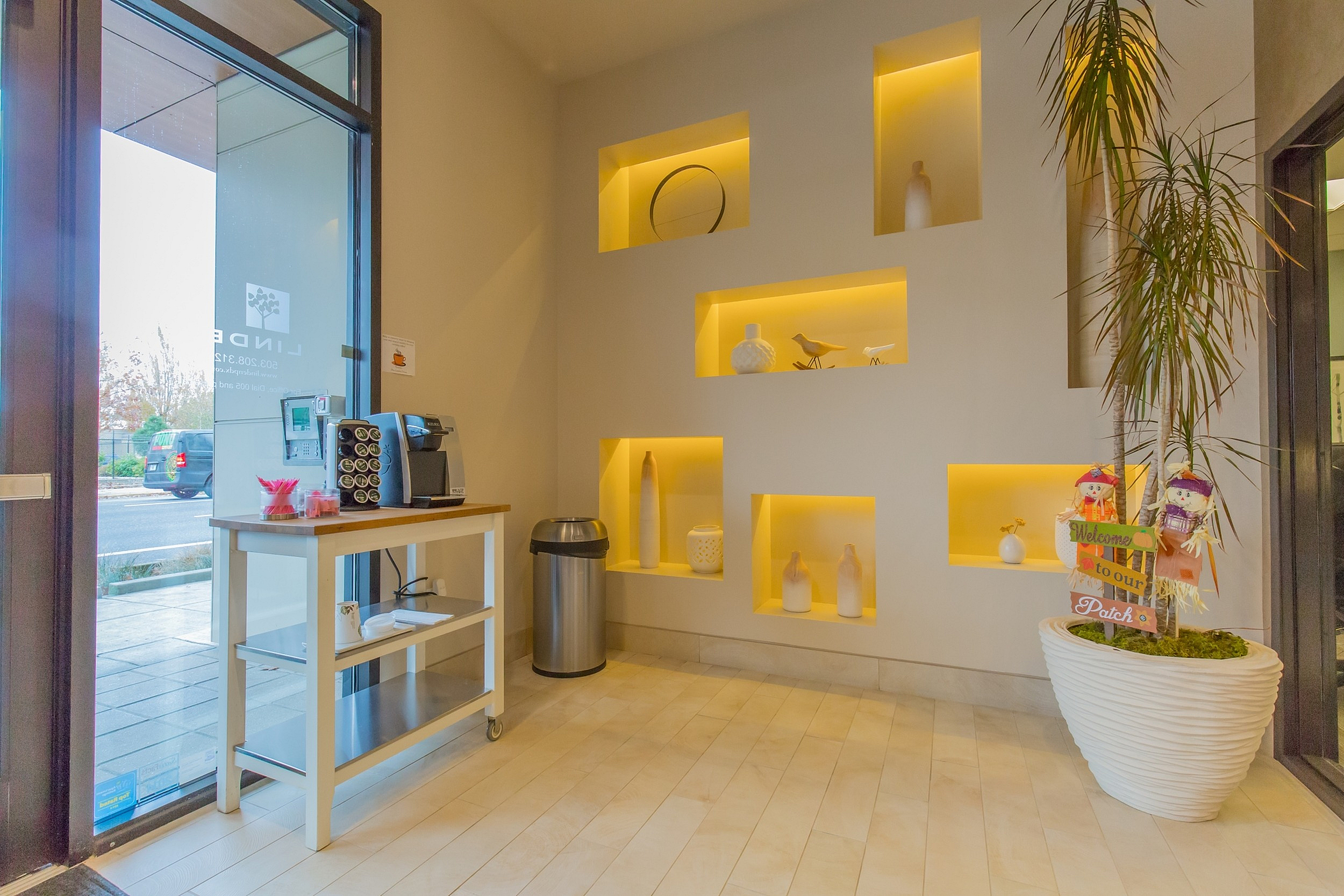 Inviting lobby interior with modern decorative shelves, warm lighting, and a convenient coffee station.