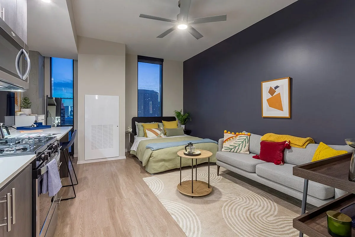 Modern studio apartment showcasing an open layout with a stylish kitchen, cozy sleeping area, and inviting living space featuring contemporary decor.