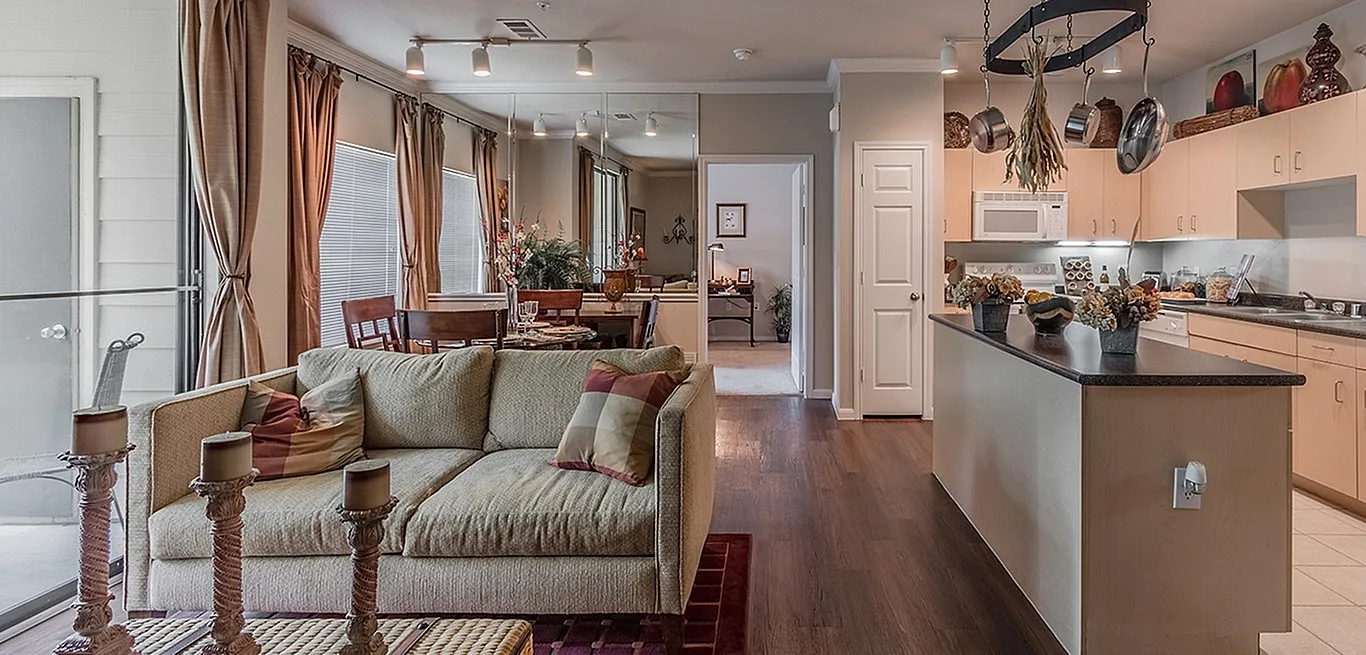 Elegant open-concept living room and kitchen with modern decor, featuring cozy seating, stylish dining area, and sleek hardwood floors.