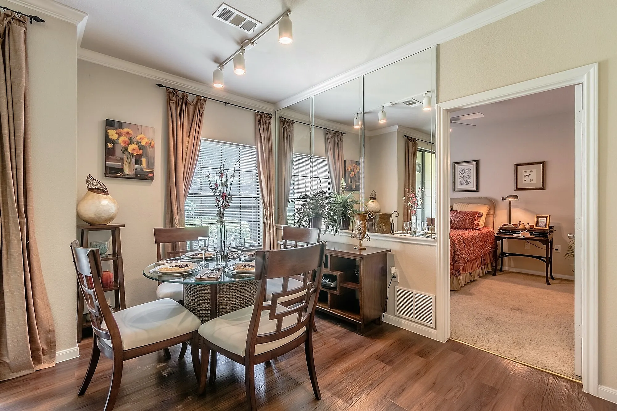 Charming dining area with elegant decor, wooden flooring, and a glimpse into a cozy bedroom, perfect for stylish living.