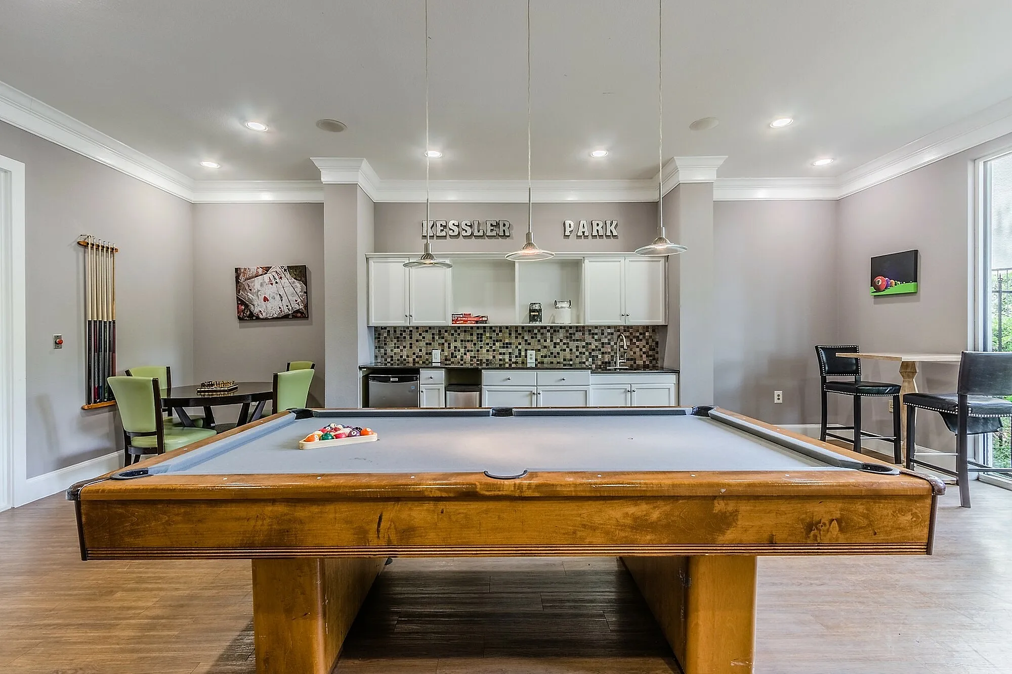 Chic game room with a billiard table, modern lighting, and a cozy seating area, perfect for entertaining in style.
