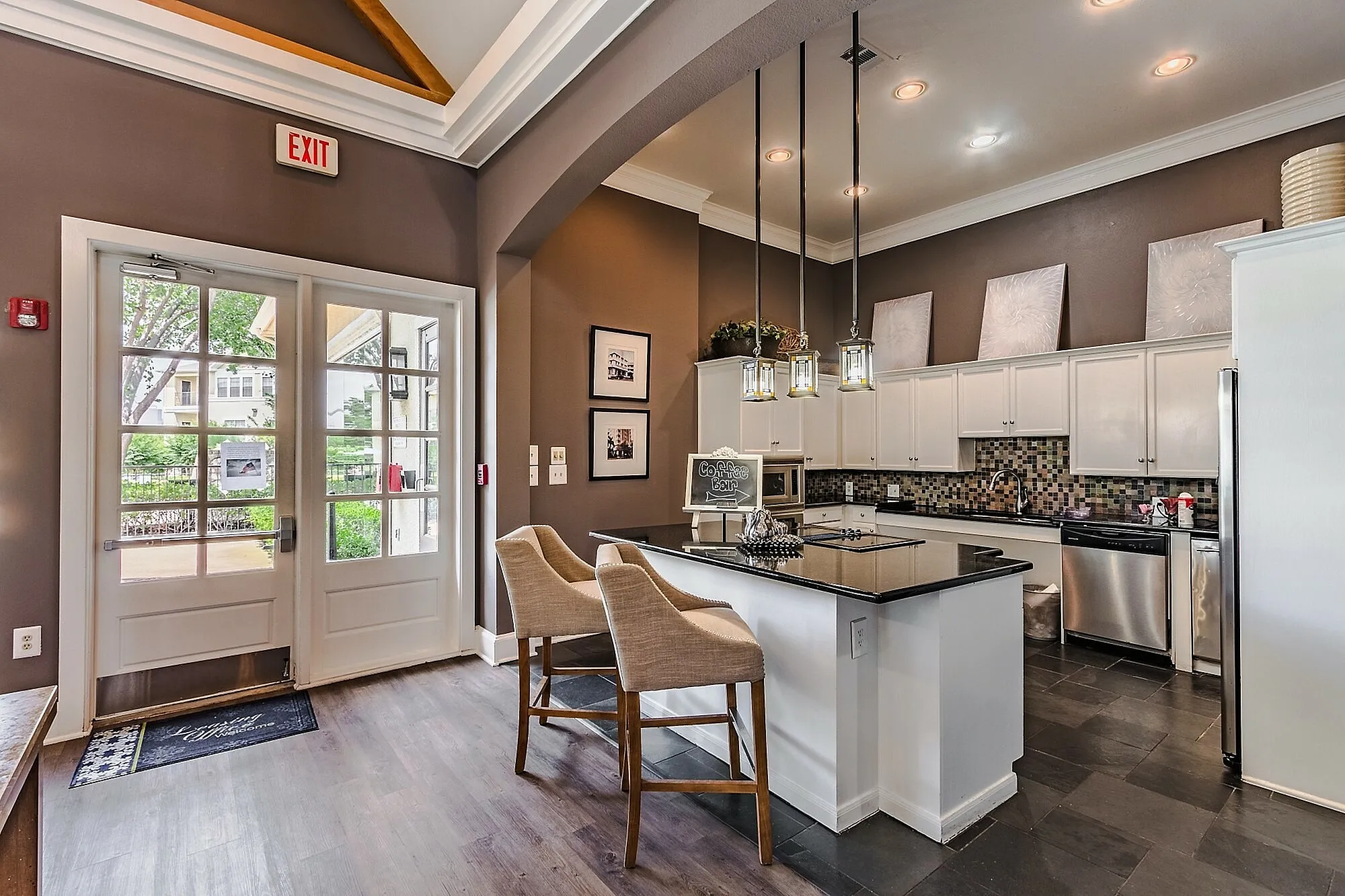 Chic kitchen design with elegant pendant lighting, modern bar stools, and a sleek island for a luxurious living space.