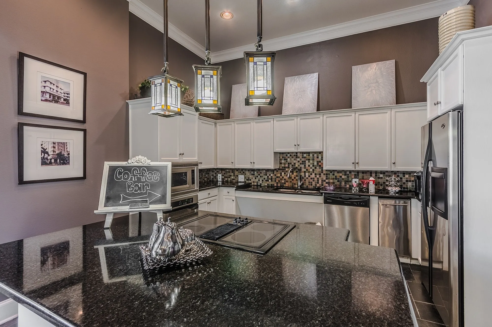 Elegant modern kitchen with sleek granite countertops, stainless steel appliances, and stylish lantern pendant lighting.