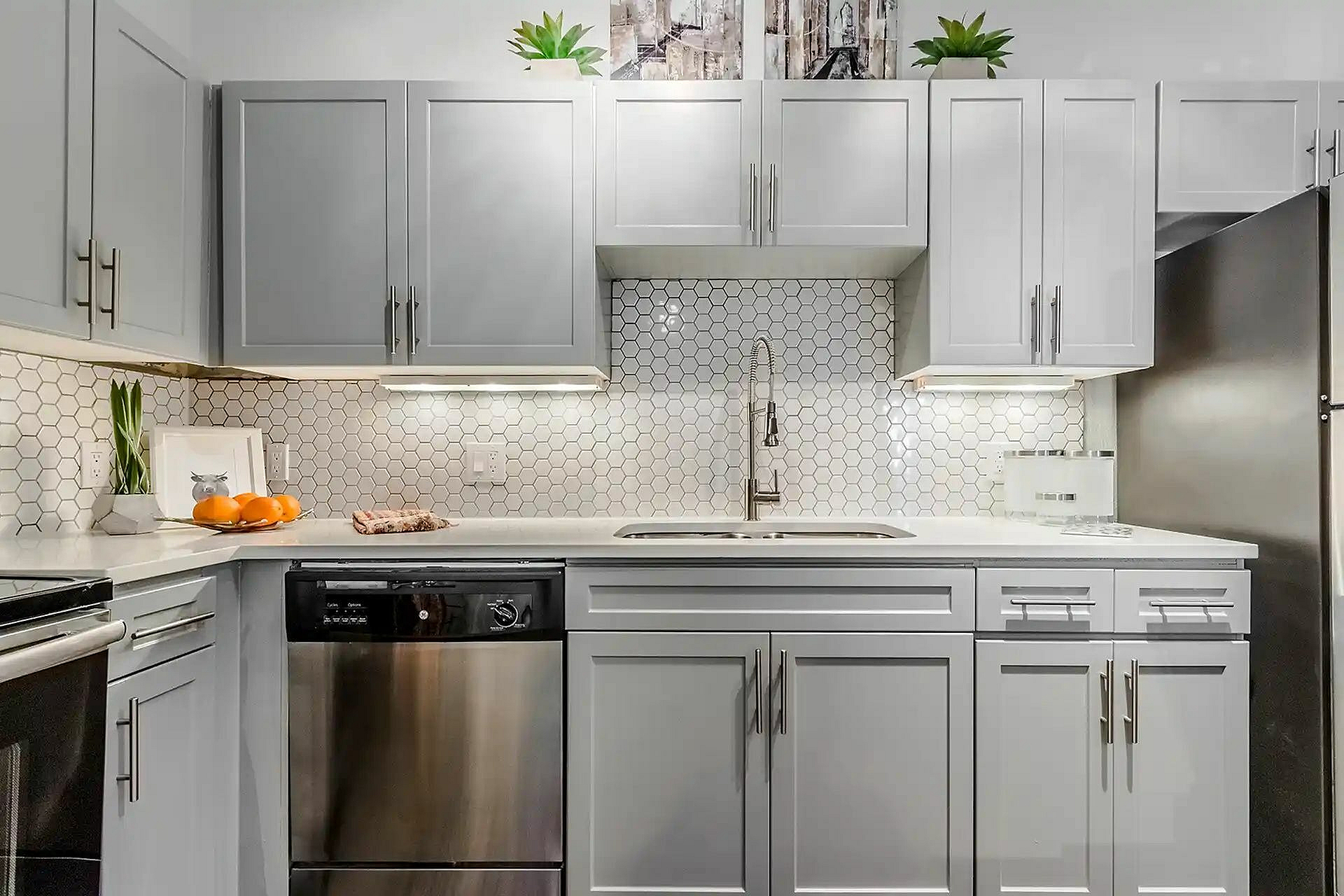 Modern kitchen with elegant cabinetry, sleek stainless steel appliances, and a stylish hexagonal tile backsplash.