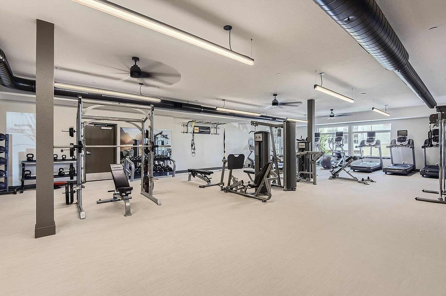 State-of-the-art fitness center with modern gym equipment, featuring a variety of cardio machines and weight stations.