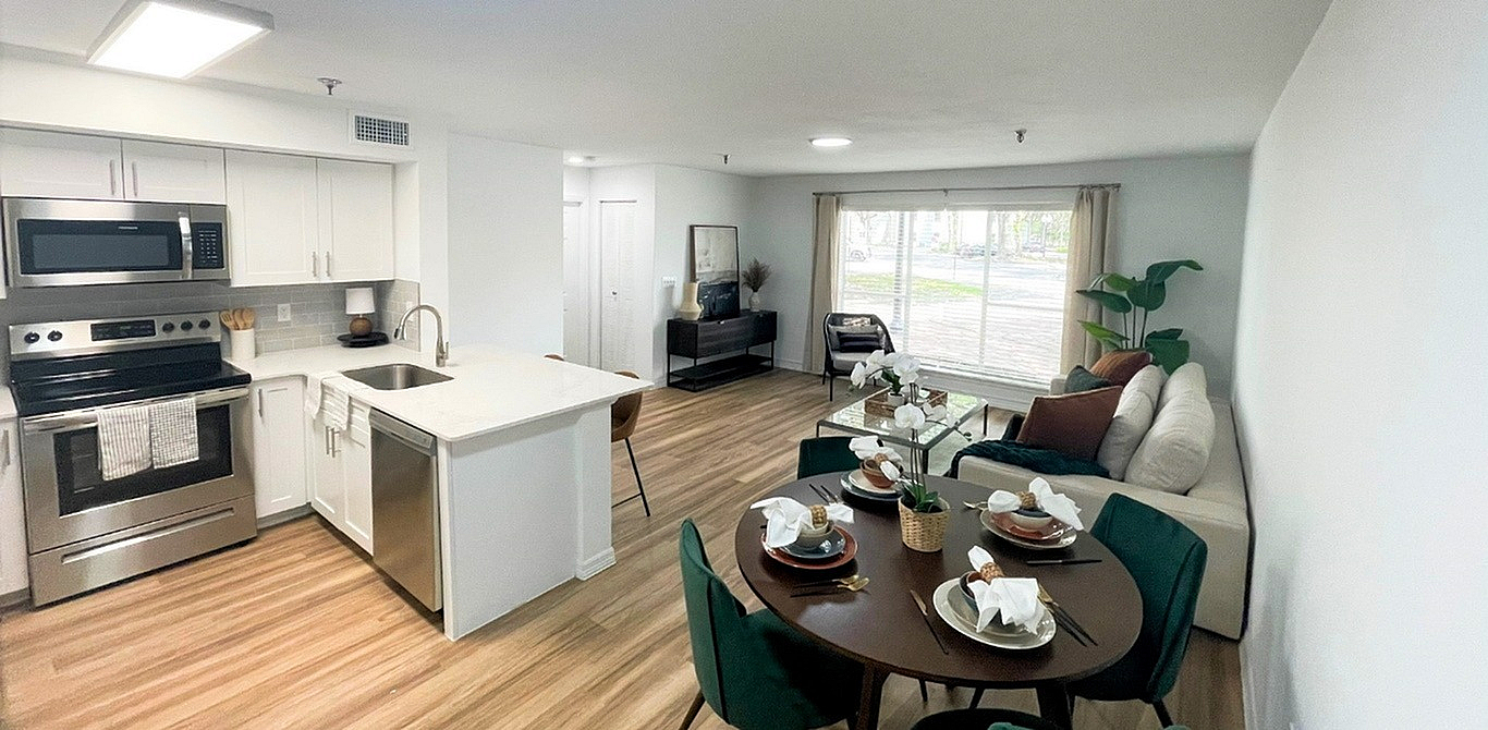 Modern open-plan kitchen and living space with elegant dining area, stainless steel appliances, and a bright, inviting atmosphere.