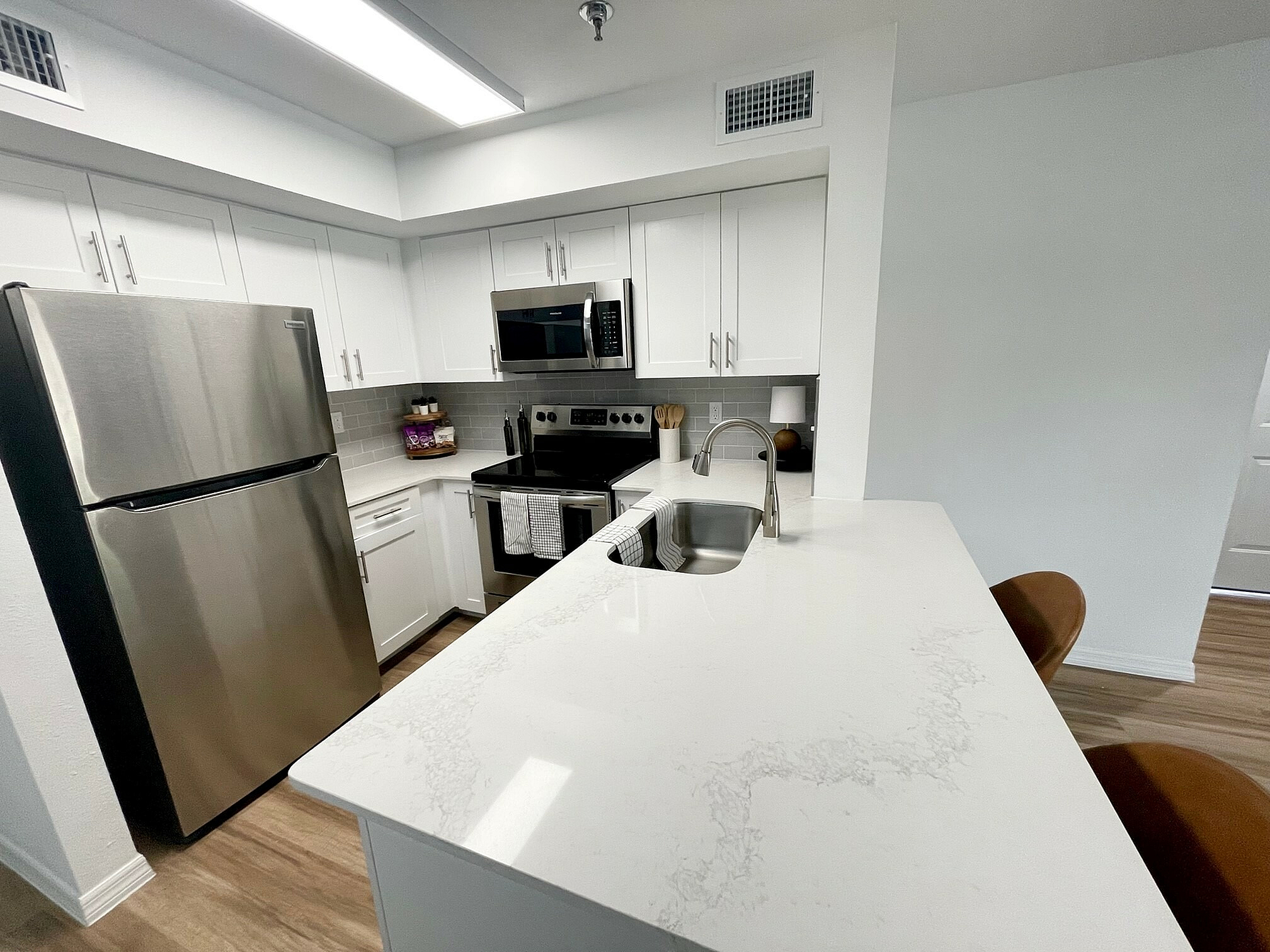Modern kitchen with sleek stainless steel appliances, elegant white cabinetry, and a luxurious marble countertop.
