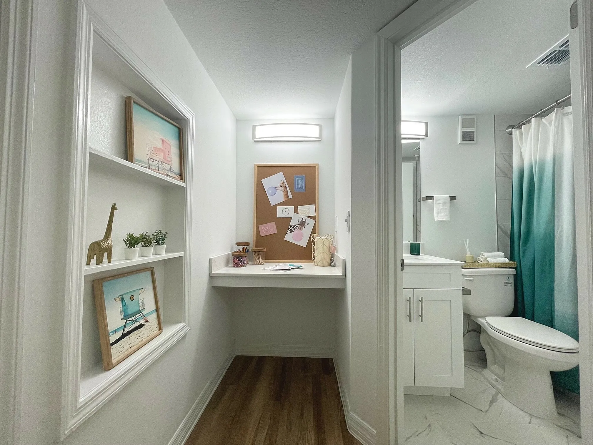Charming hallway with decorative shelving and a cozy workspace leading to a modern bathroom with elegant finishes.