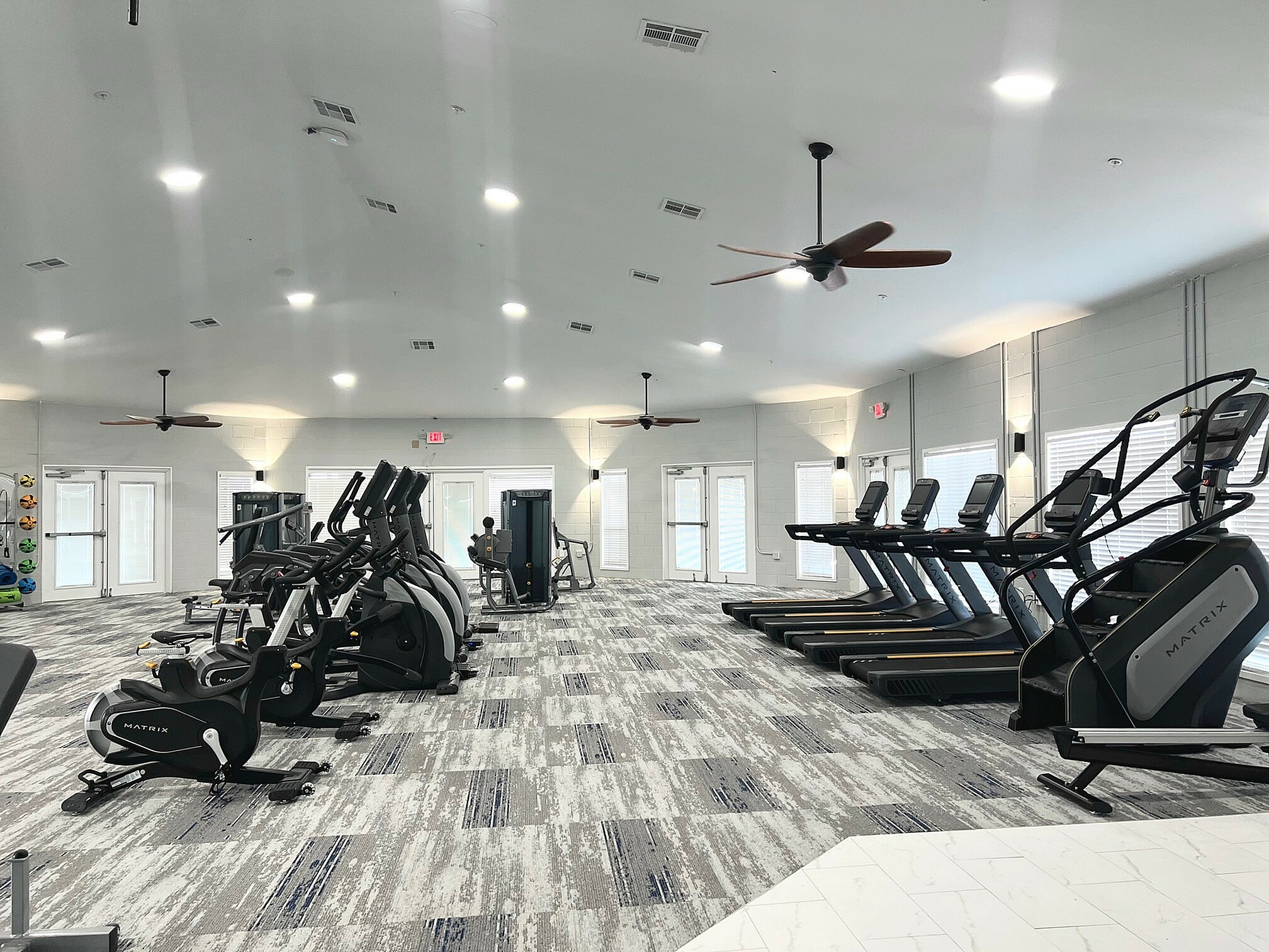 Modern fitness center with state-of-the-art exercise equipment, including treadmills and elliptical machines, set in a spacious, well-lit environment.
