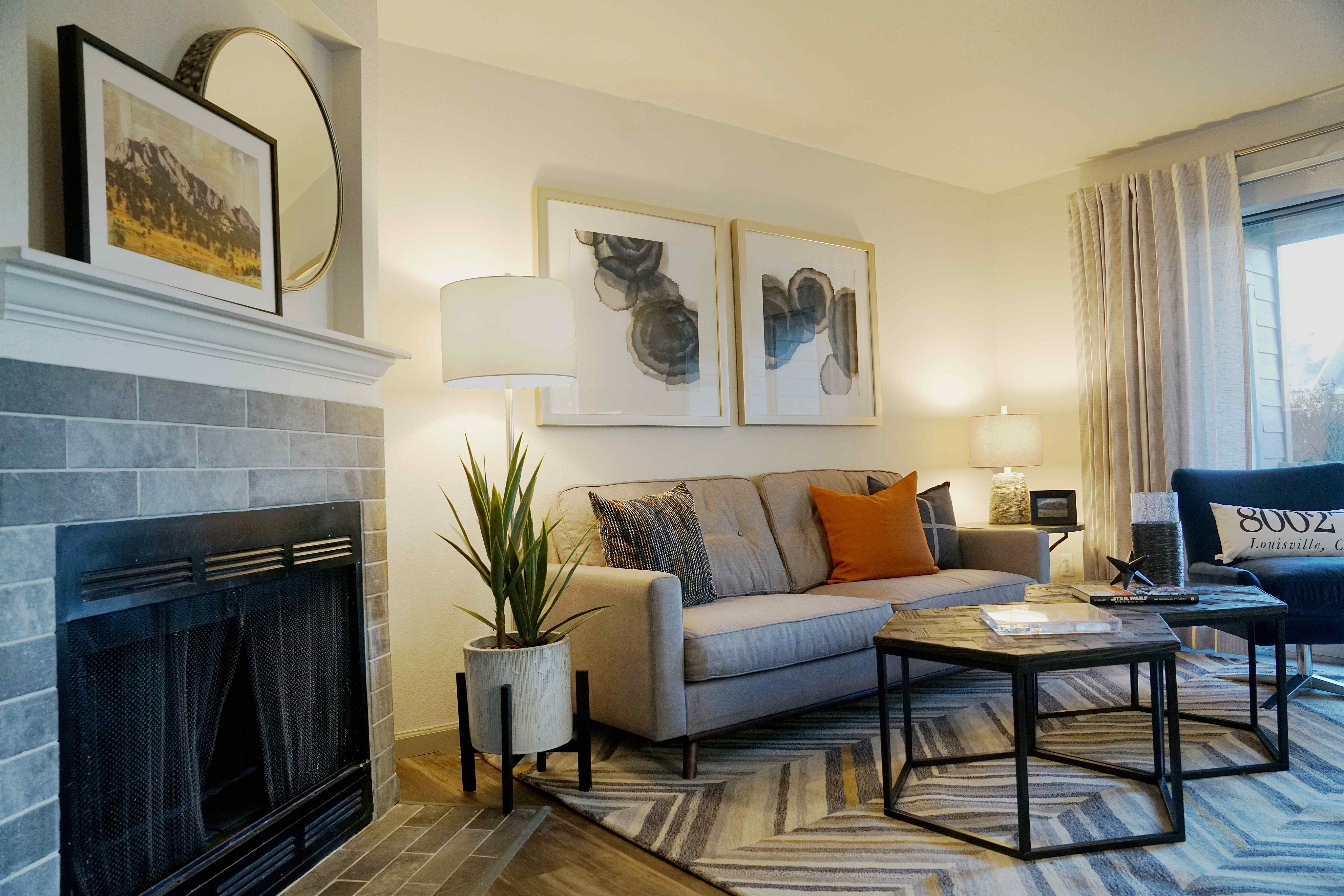 Cozy and stylish living room featuring a comfortable gray sofa with vibrant cushions, elegant fireplace, and modern decor accents.