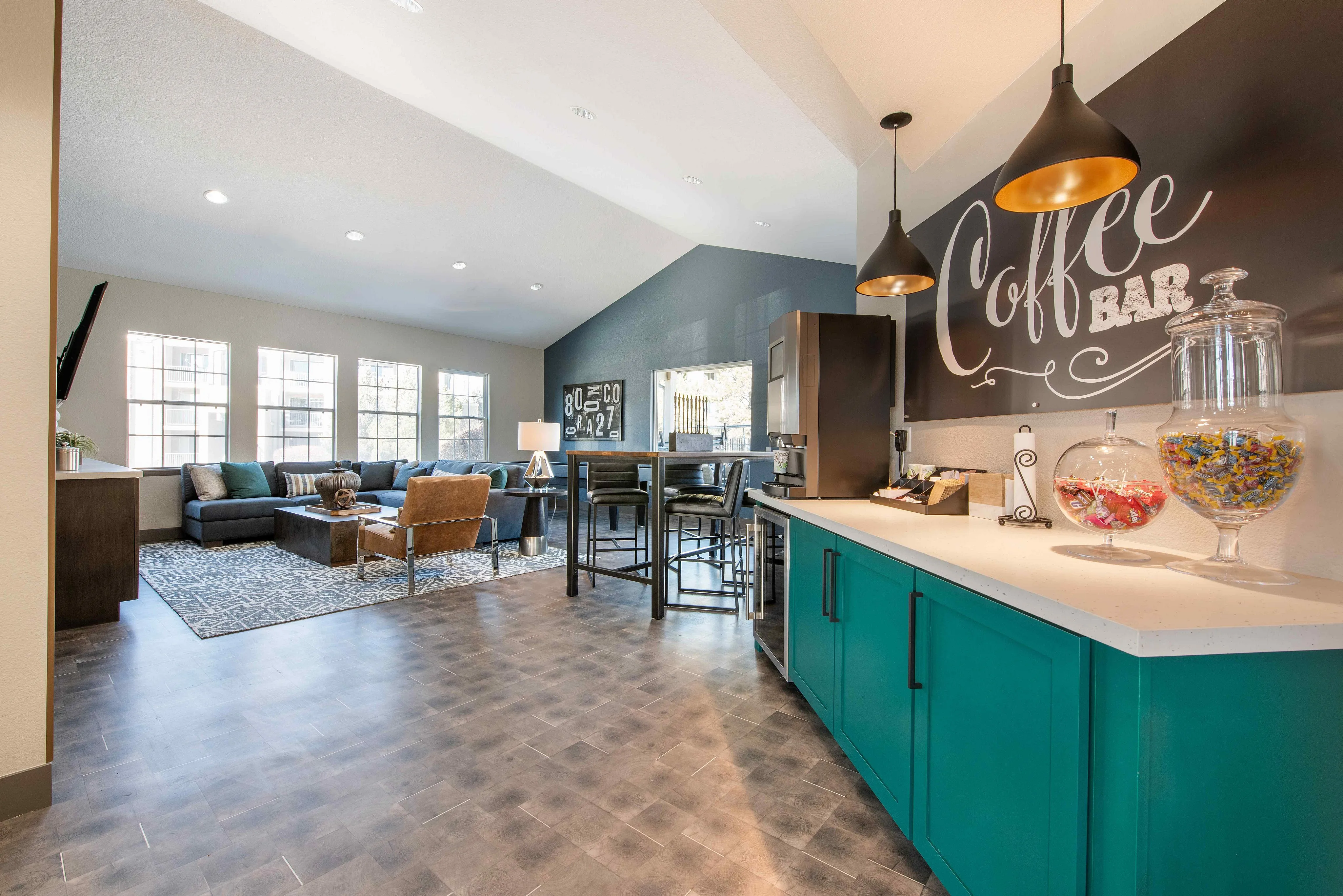 Inviting living space with vibrant coffee bar, chic pendant lighting, and cozy seating, perfect for relaxation and socializing.