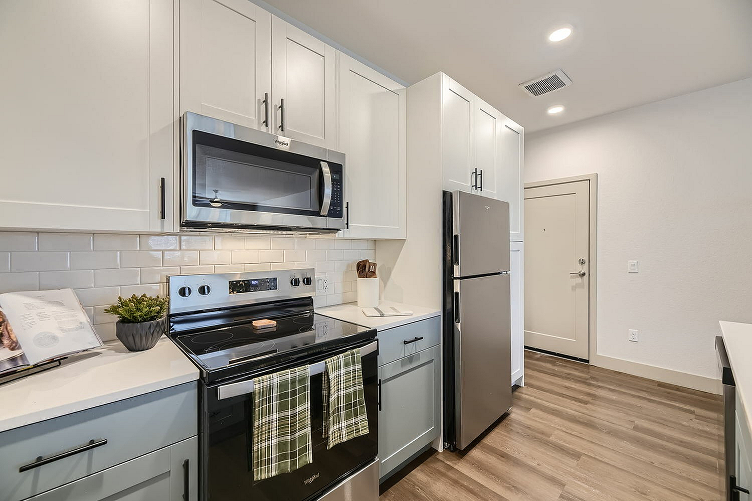 Modern kitchen with sleek stainless steel appliances, elegant white cabinetry, and stylish tile backsplash.