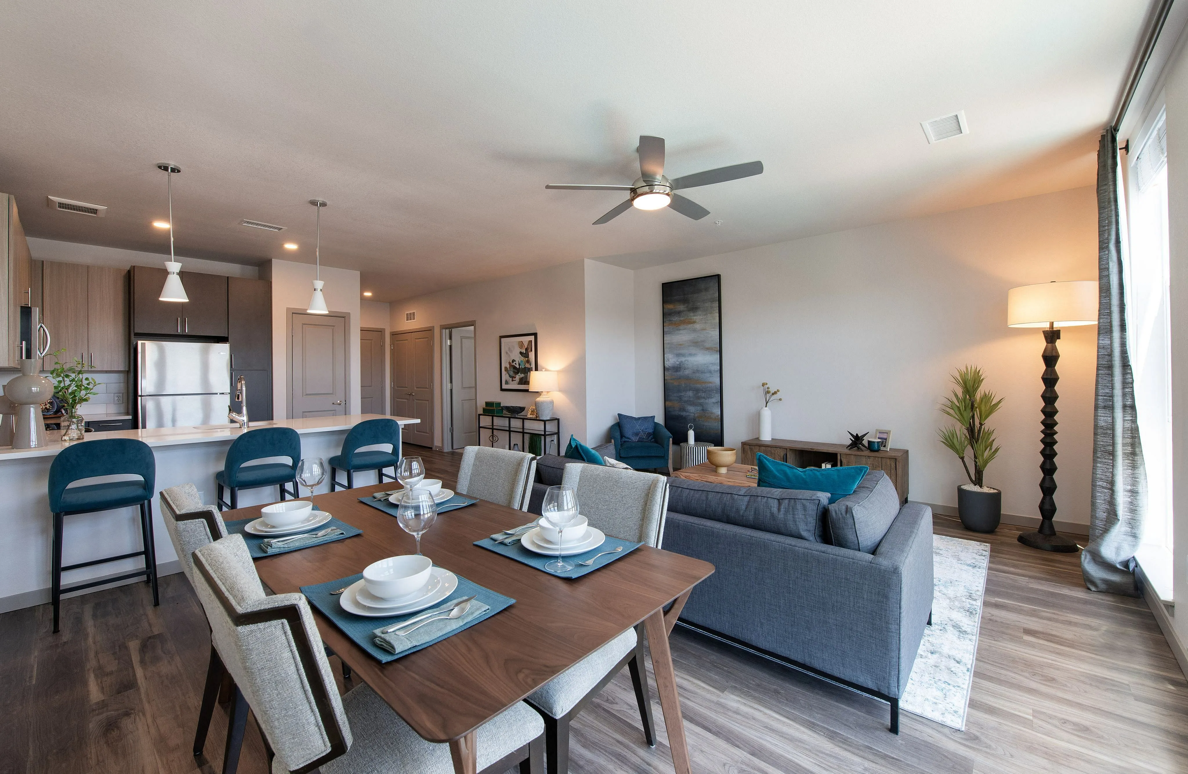 Elegant open-concept living and dining area featuring modern decor, a sleek kitchen with stainless steel appliances, and ample natural light.