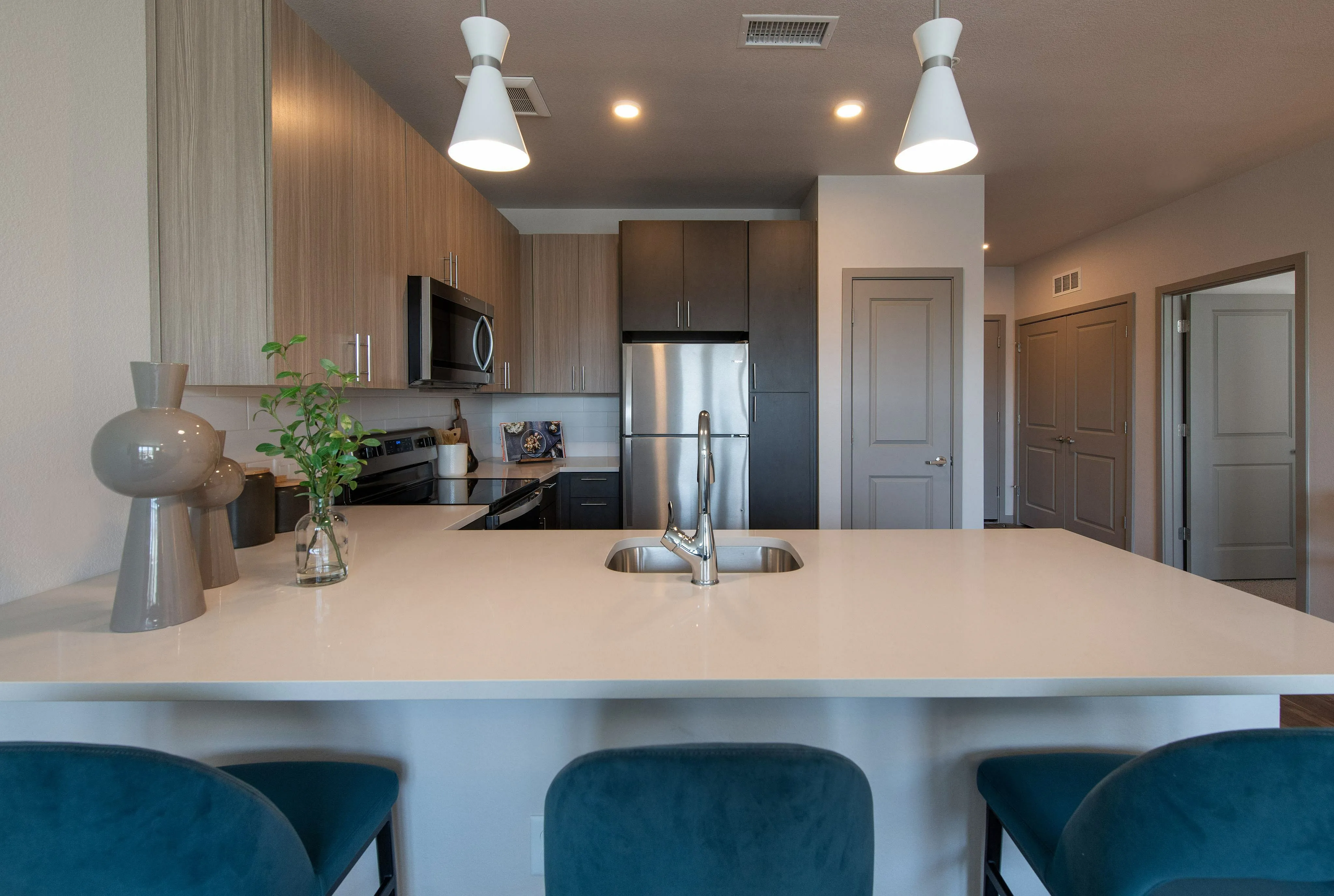 Modern kitchen with sleek cabinetry, stainless steel appliances, and a spacious island with chic pendant lighting.