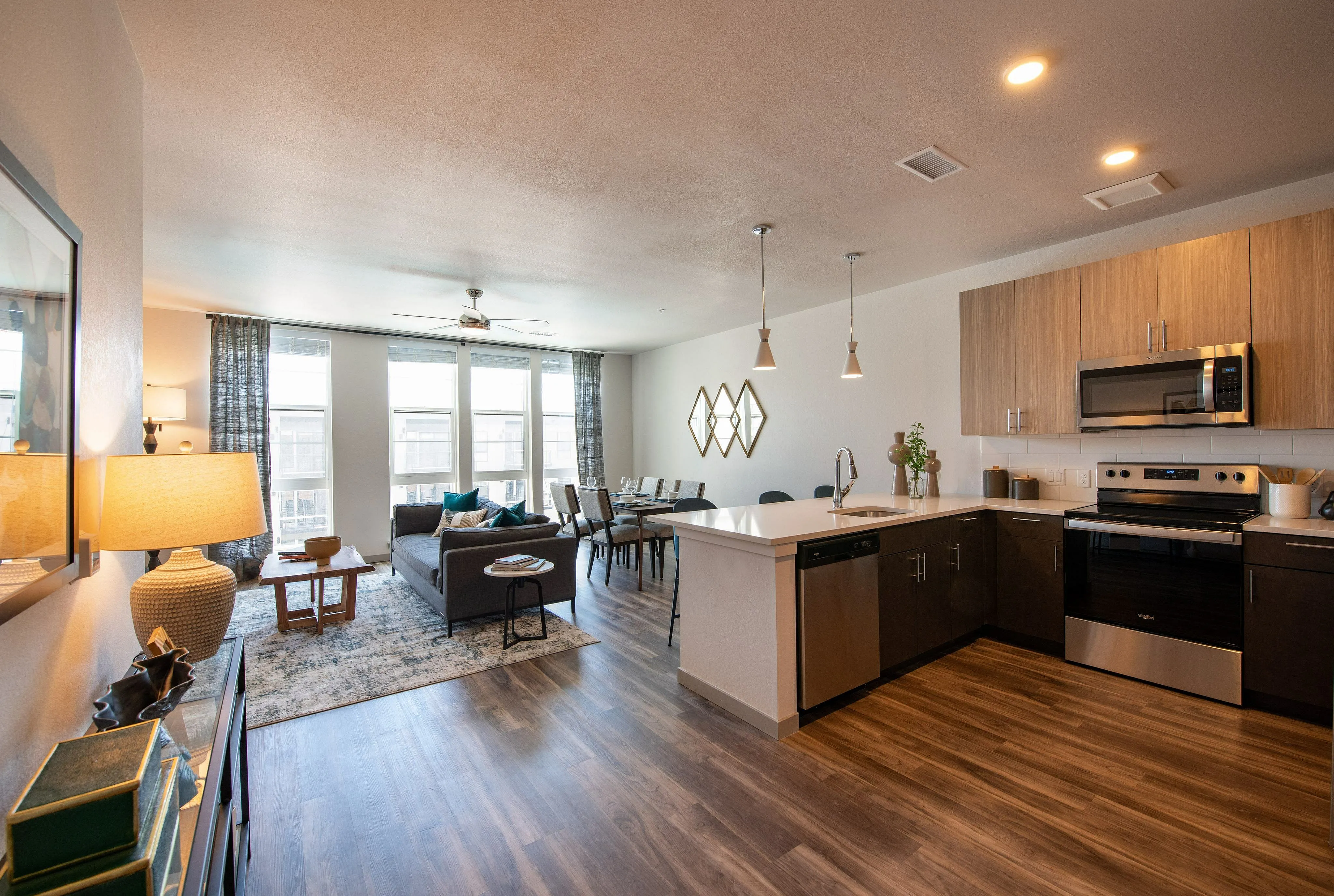 Chic open-concept apartment interior featuring a modern kitchen, stylish living area with large windows, and elegant dining space.