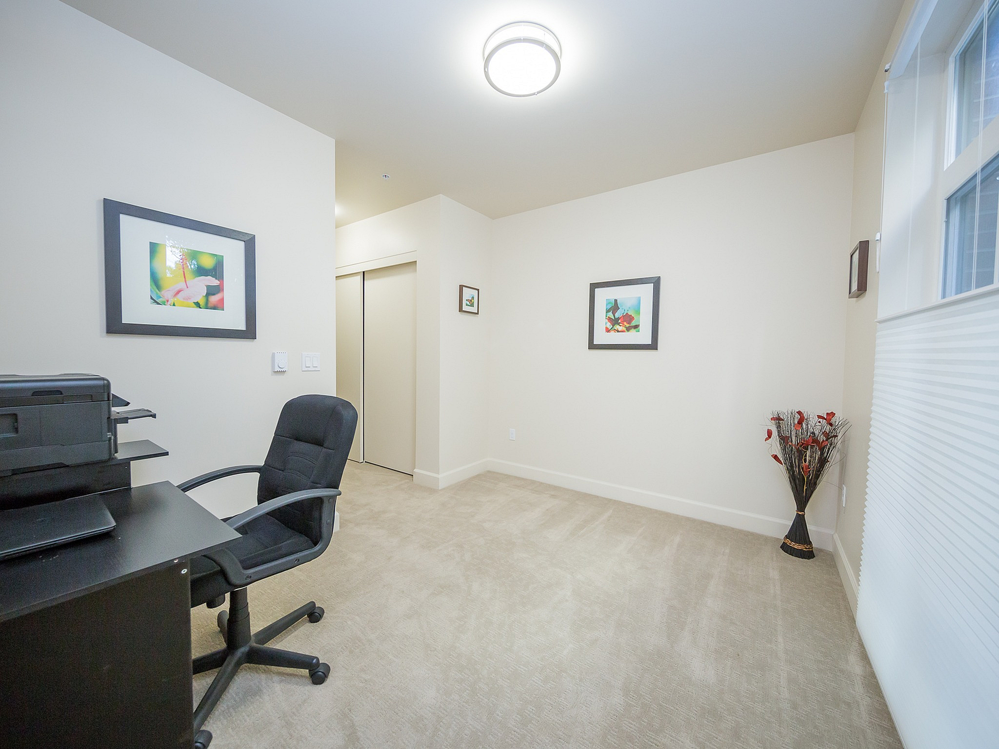 Bright home office with modern desk, ergonomic chair, stylish decor, and ample natural light from a large window.