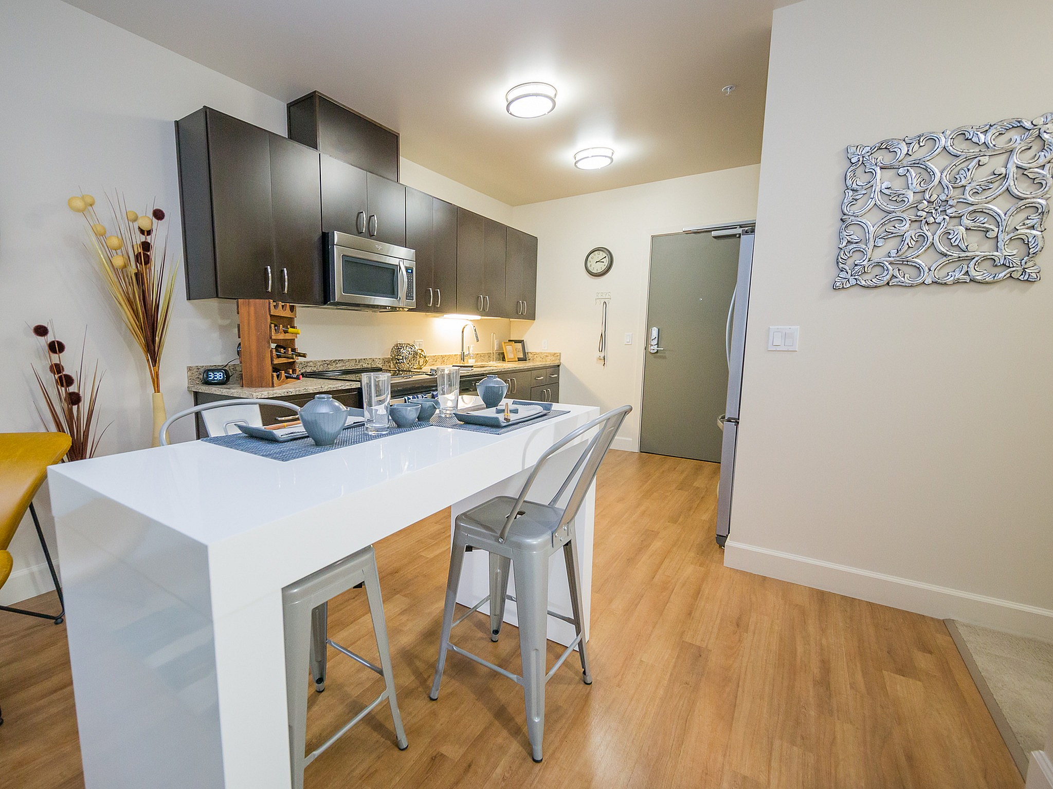 Modern kitchen with sleek white island, contemporary bar stools, and stylish cabinetry, perfect for entertaining.
