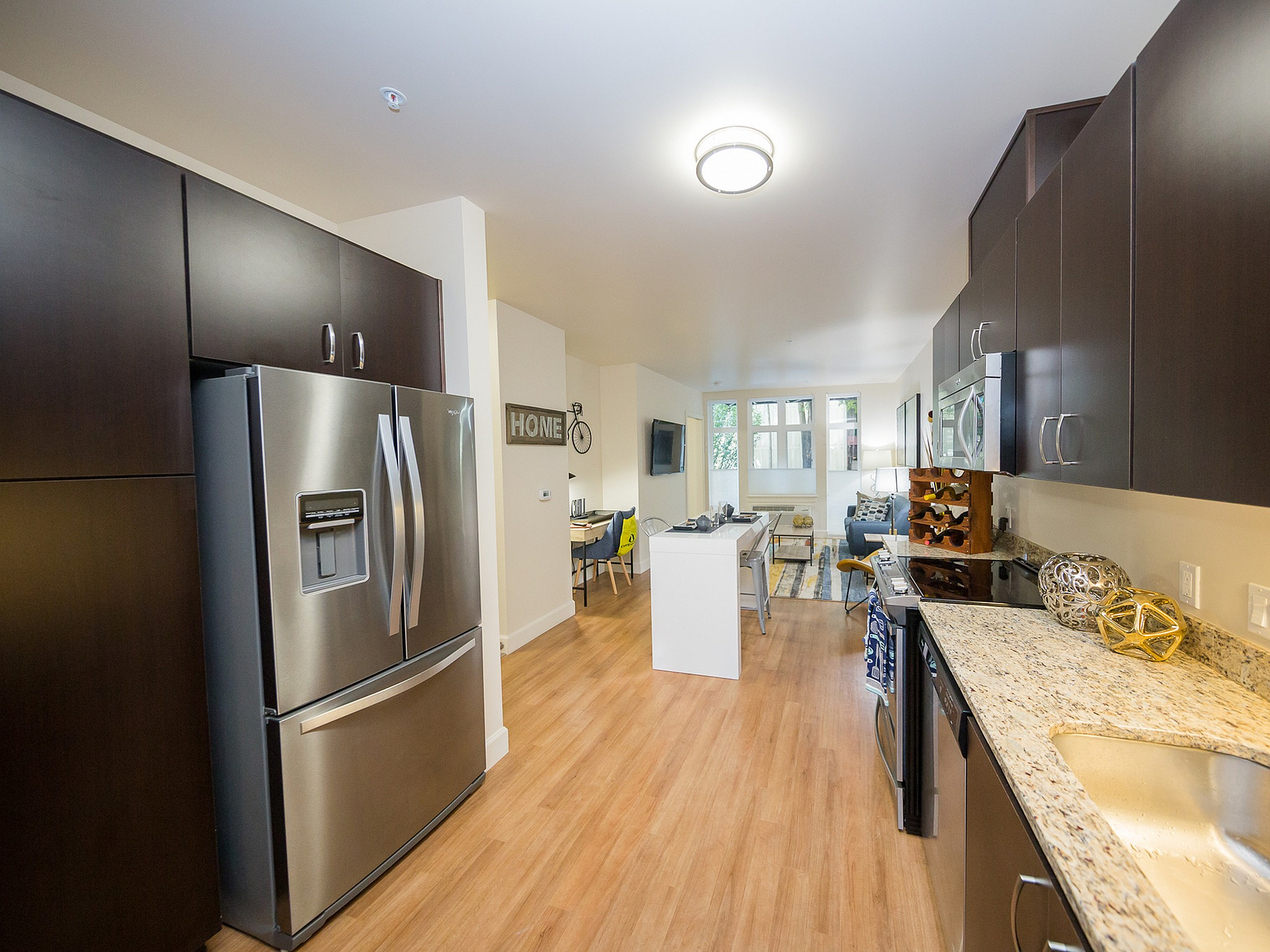 Modern kitchen with sleek stainless steel appliances, spacious countertops, and open layout leading to an inviting living area.
