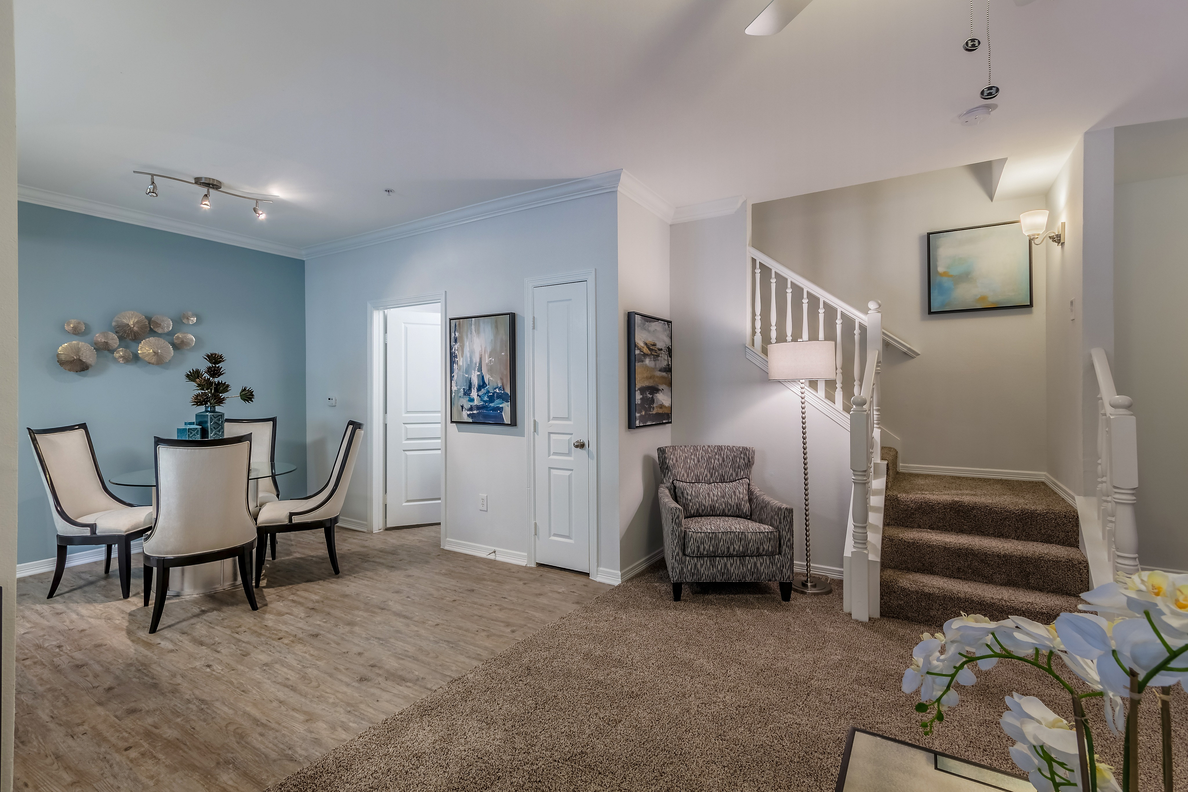 Elegant and inviting living space featuring modern decor, stylish dining area, and a cozy staircase.