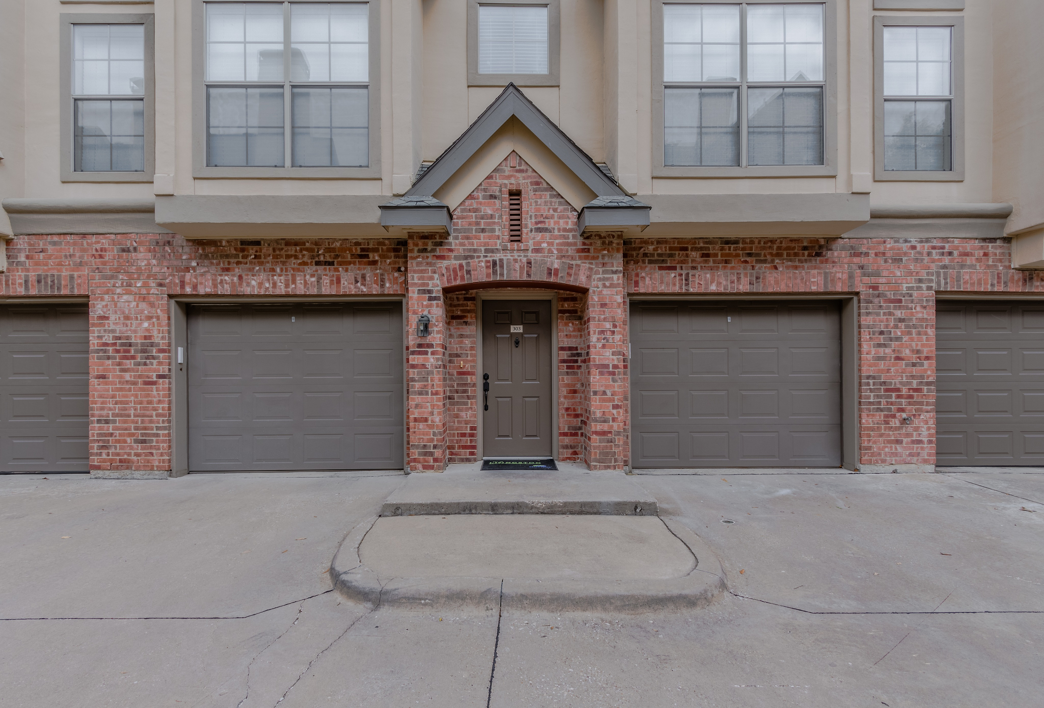 Stunning townhouse entrance with elegant brick facade and dual garages.