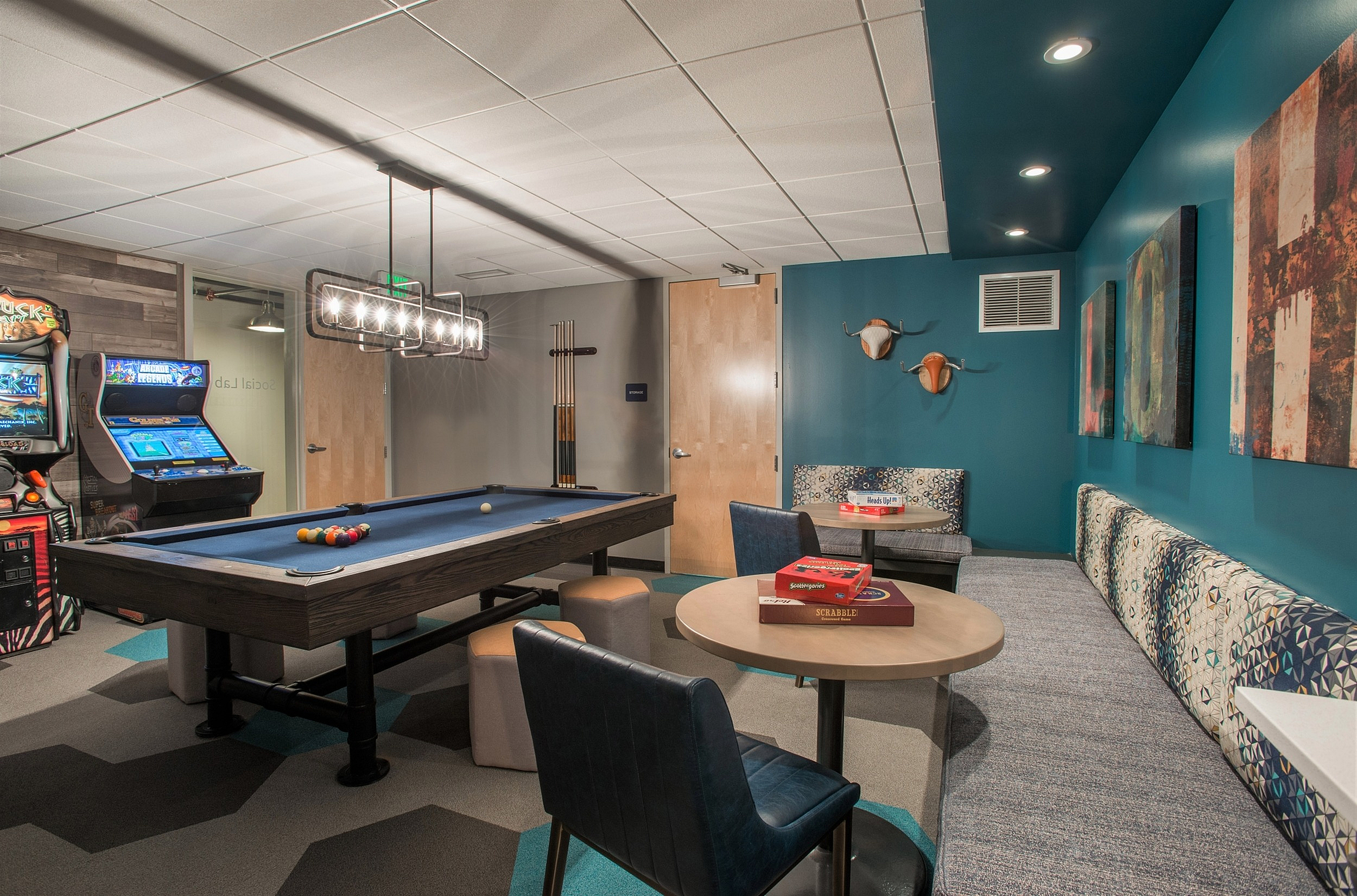 Chic recreation room featuring a sleek pool table, cozy seating area, and vibrant arcade games, perfect for entertainment and relaxation.