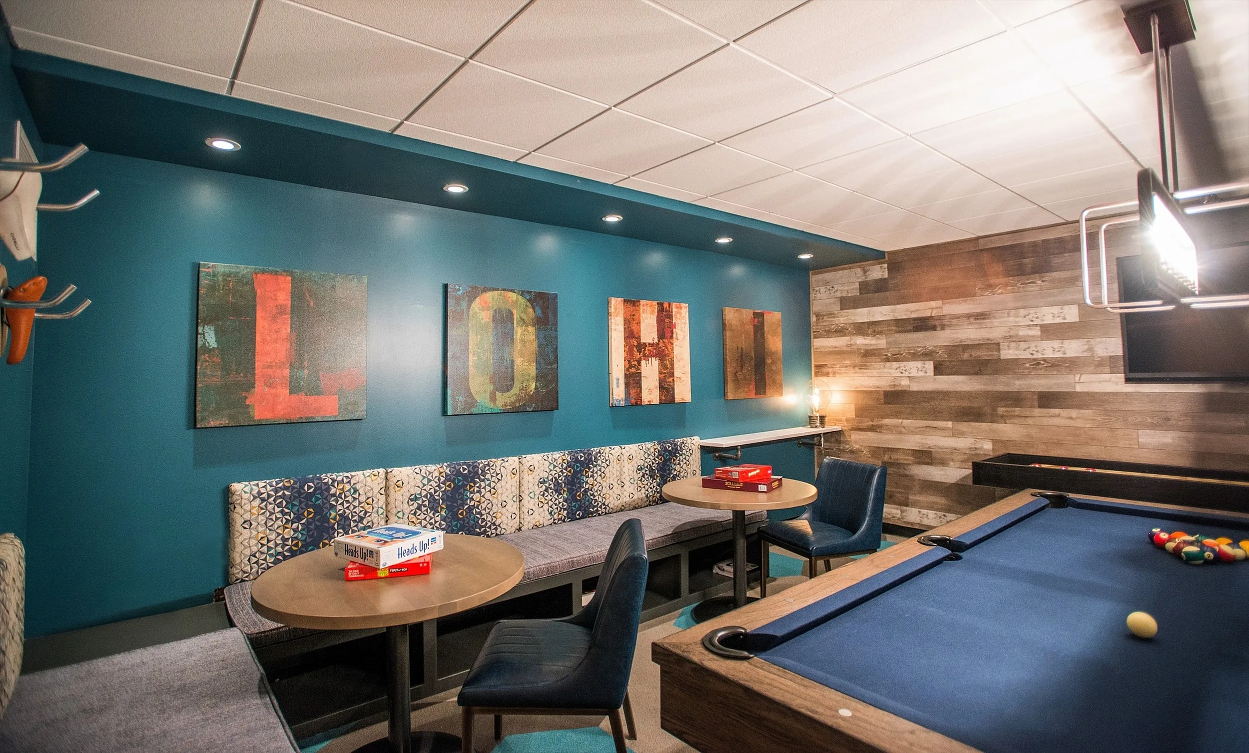 Chic game room with vibrant artwork, elegant seating, and a stylish billiard table, perfect for entertaining and relaxation.