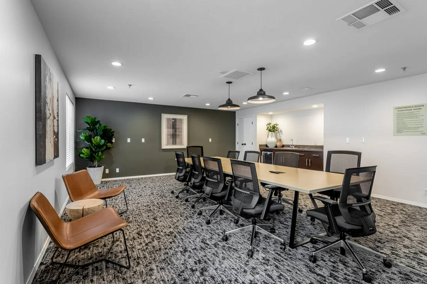 Modern conference room with sleek black chairs around a long table, stylish decor, and warm lighting creating a professional atmosphere.