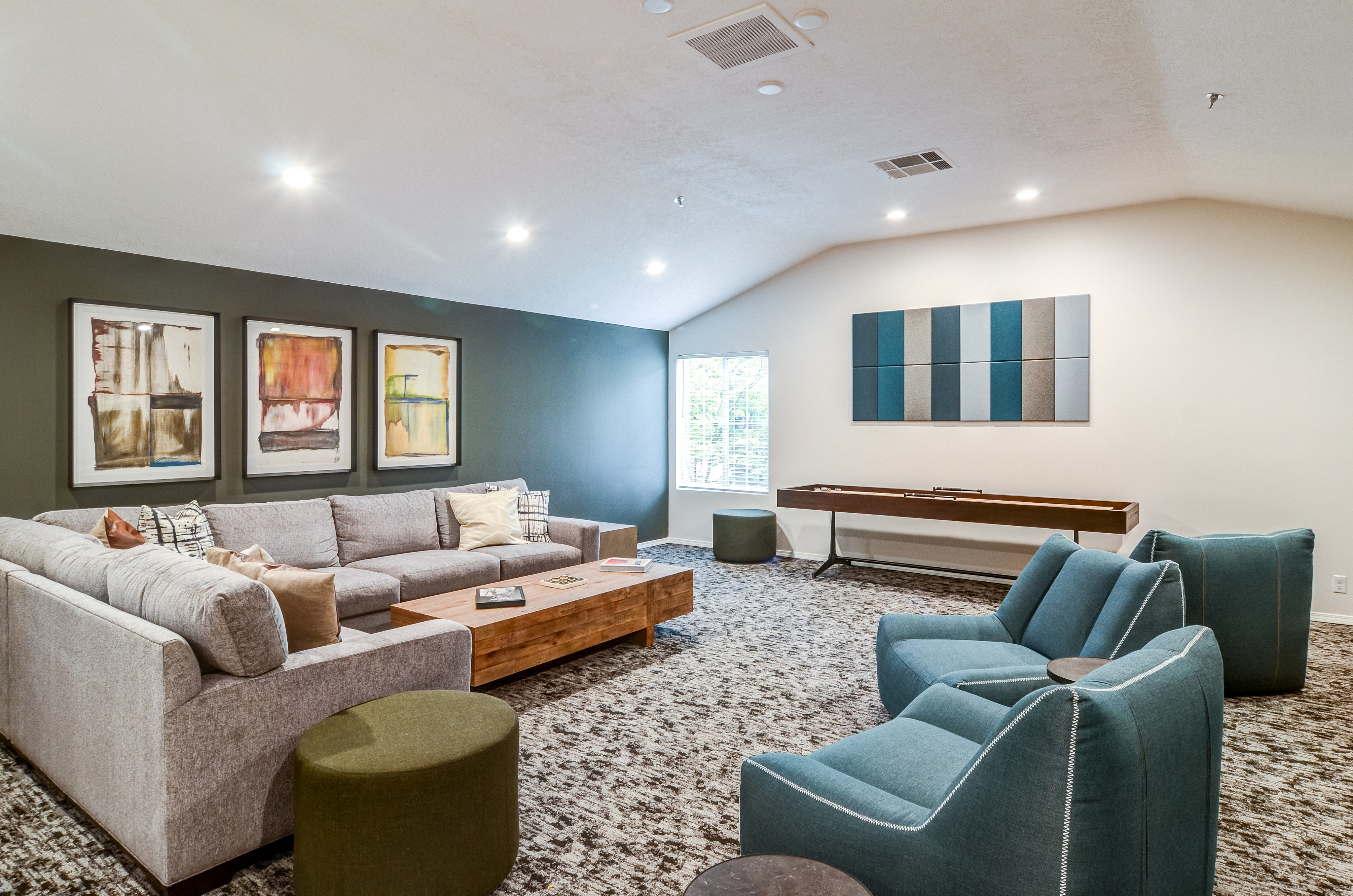 Elegant living room with a cozy sectional couch, stylish artwork, and contemporary accent chairs, creating an inviting space for relaxation.