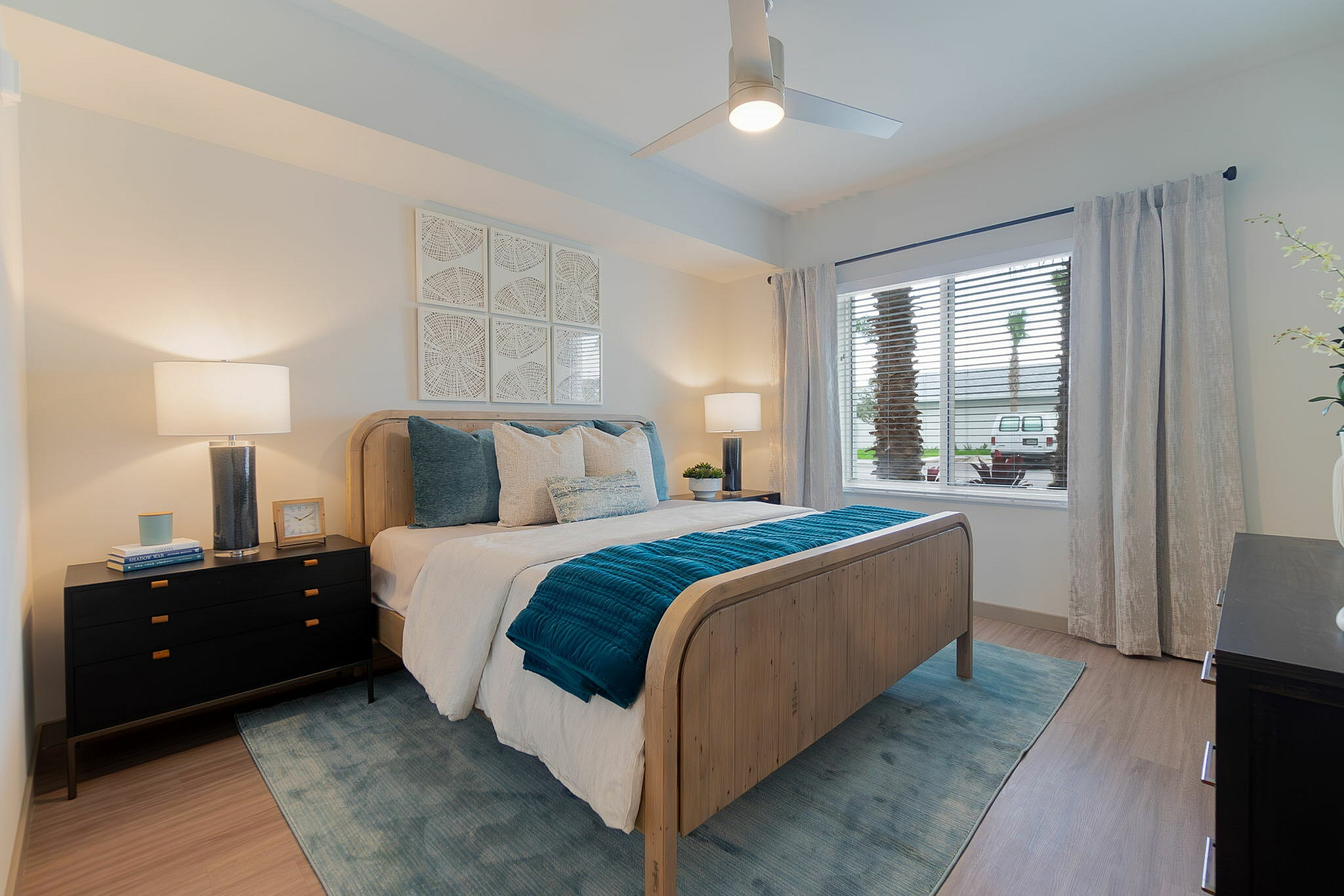 Bright and inviting bedroom with stylish decor, featuring a cozy bed, elegant nightstands, and a large window allowing natural light.