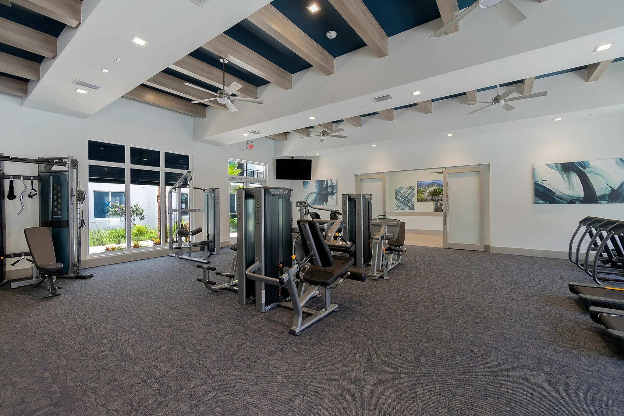 Modern fitness center with state-of-the-art gym equipment, natural lighting, and contemporary design.