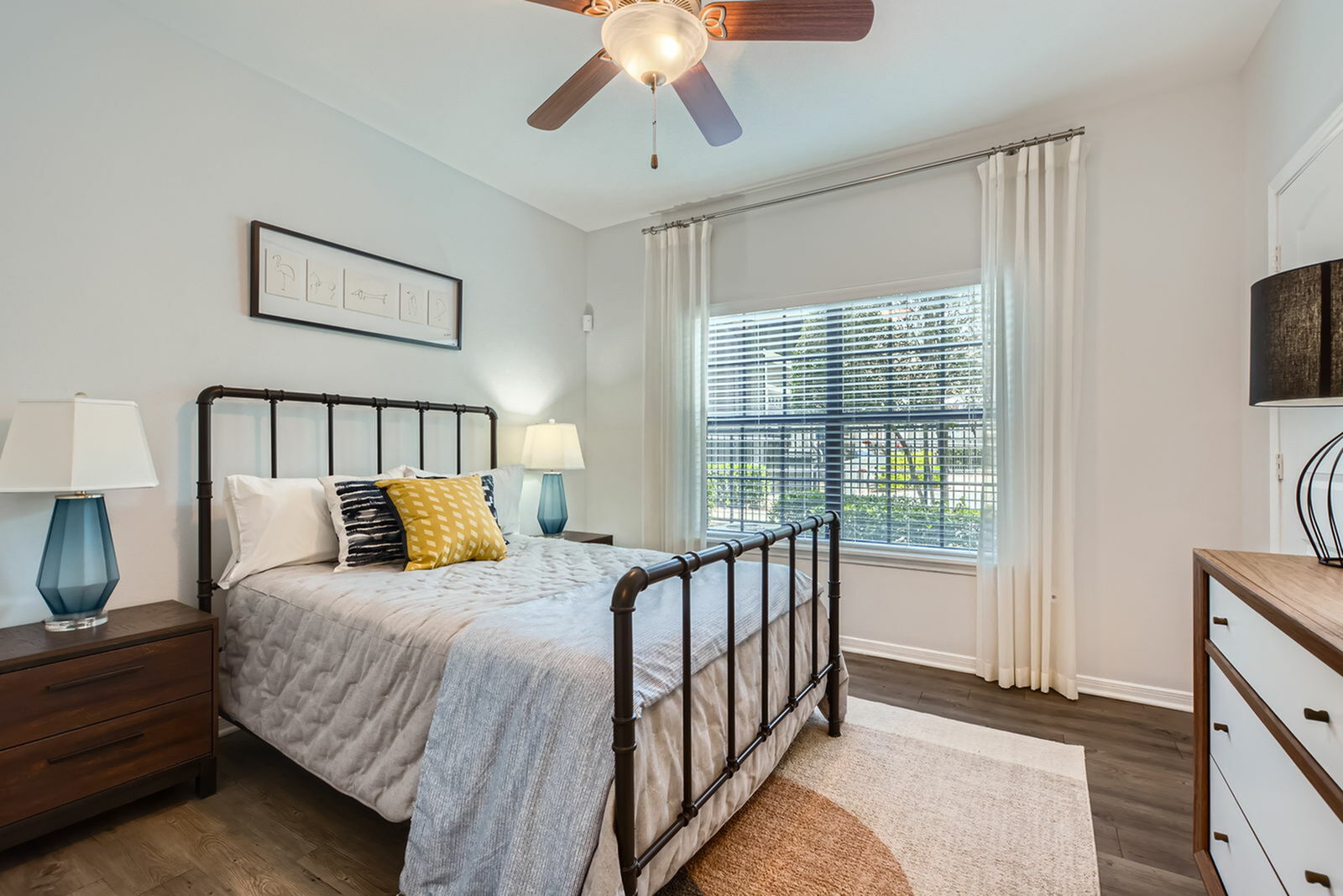 Inviting bedroom with stylish decor, featuring a cozy bed, elegant nightstands, and large window letting in natural light.