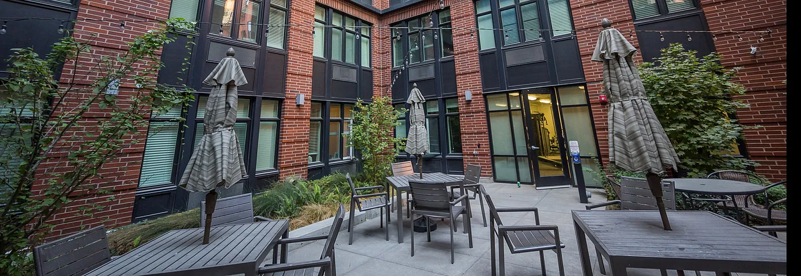 Inviting courtyard in a modern apartment building with outdoor seating and stylish brick facade.