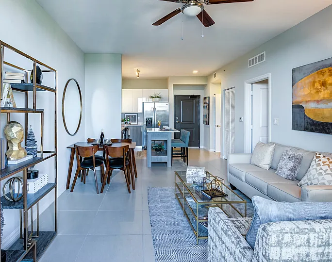 Modern open-concept living space with stylish decor, featuring a cozy seating area, elegant dining table, and sleek kitchen with stainless steel appliances.