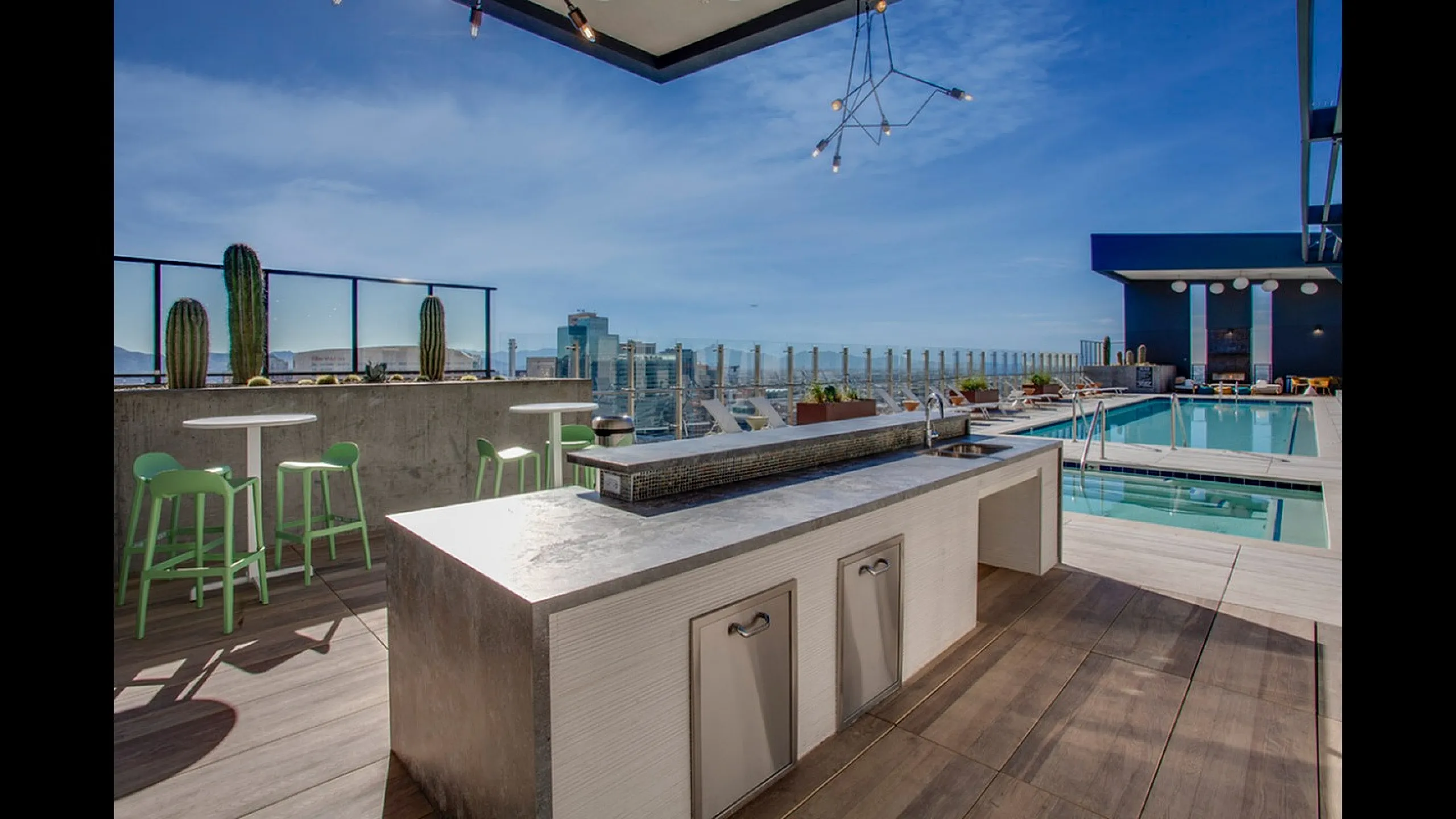 Chic rooftop terrace with modern bar seating, stunning cityscape views, and a luxurious swimming pool.