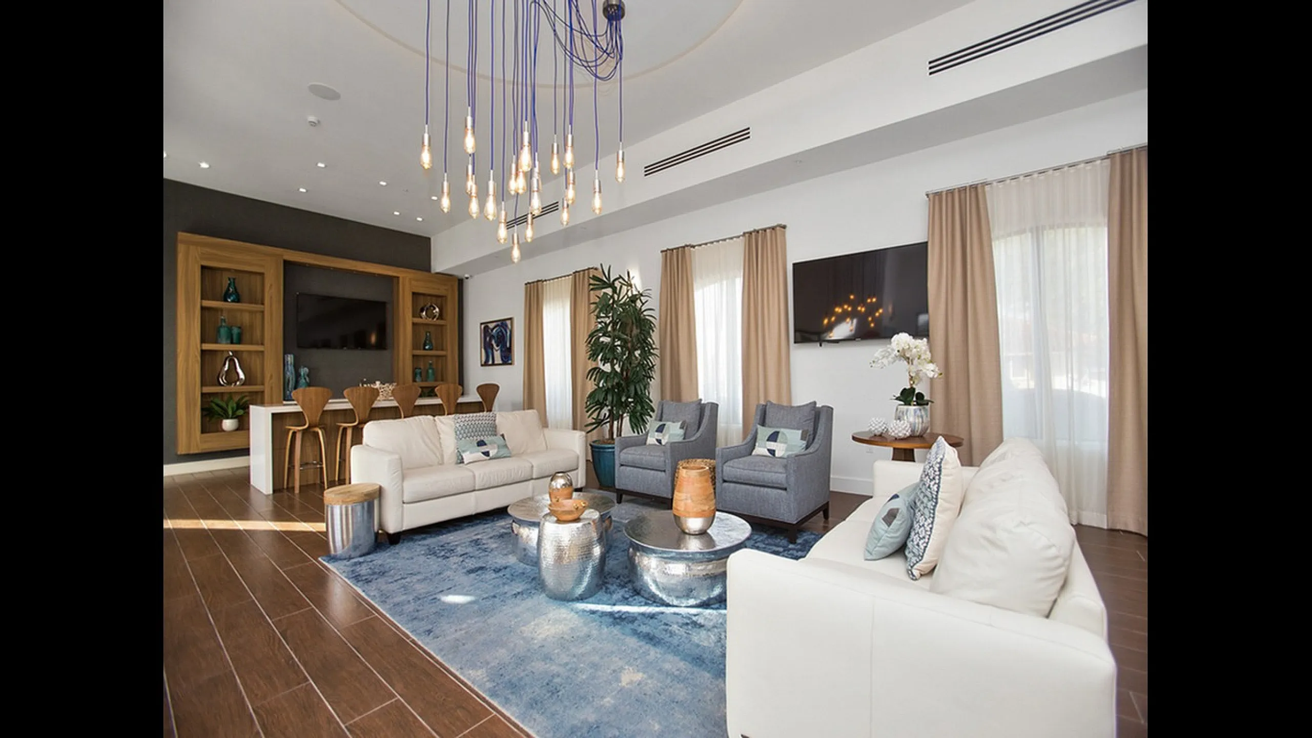Elegant and modern living room with plush sofas, chic decor, and designer lighting, perfect for luxurious relaxation and entertaining.