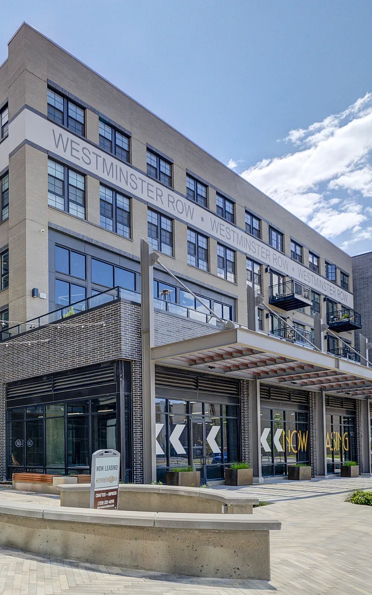 Modern urban apartment complex with sleek architecture and ample natural light, featuring rental opportunities at Westminster Row.