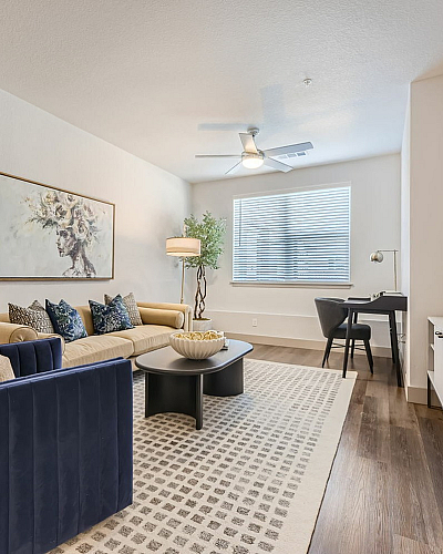 Elegant living space with modern decor, featuring a cozy seating area, stylish artwork, and a bright window scene.