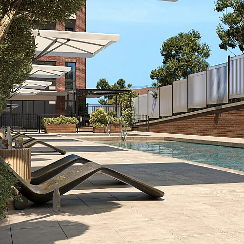 Luxurious apartment complex pool area featuring sleek lounge chairs under large umbrellas, surrounded by lush greenery and modern architecture.