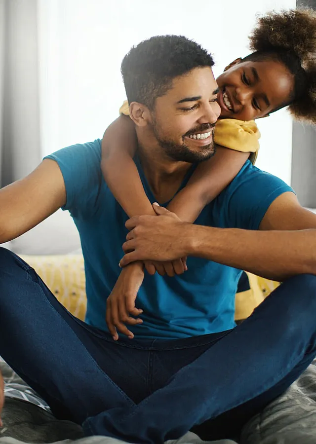 father and young daughter embracing in their apartment