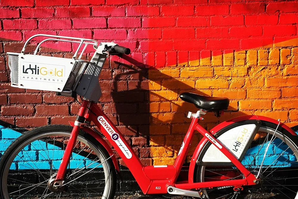 Vibrant red bike parked against a colorful mural, featuring a bright and artistic backdrop, ideal for urban exploration and a lively atmosphere.