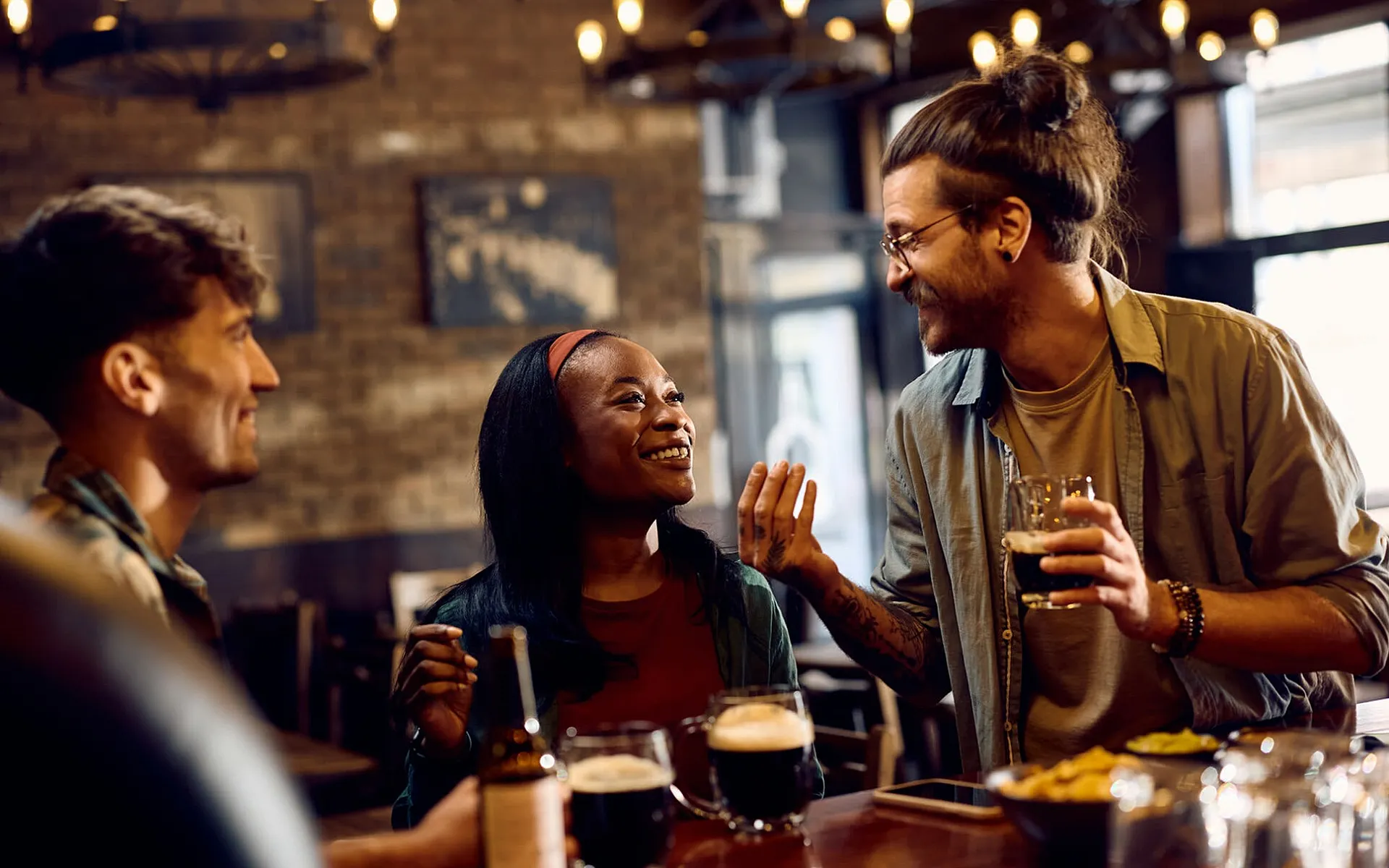 Vibrant social scene in a cozy bar with friends enjoying drinks and laughter under warm lighting.