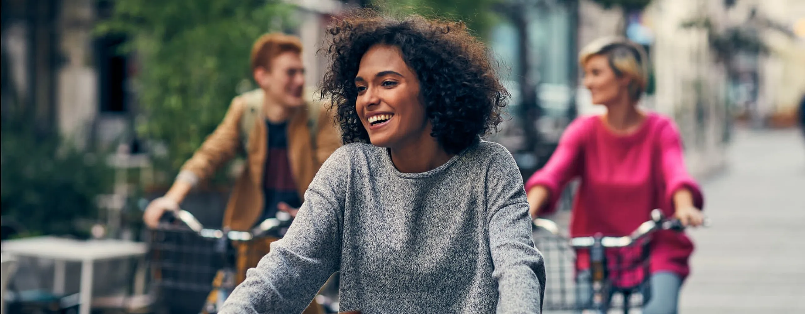 Joyful urban cycling scene with smiling people enjoying a lively city street ride.