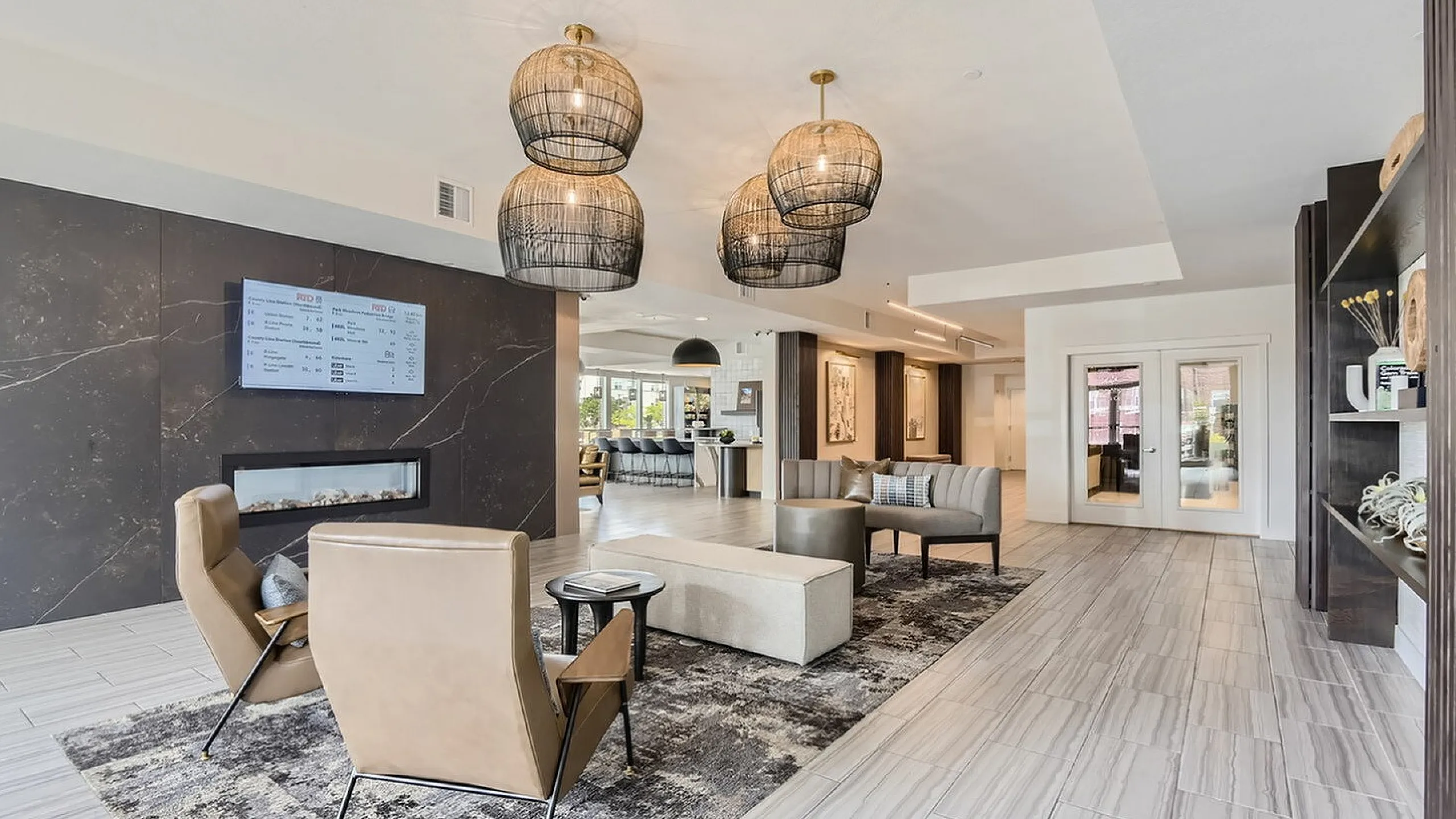 Luxurious apartment lounge with elegant decor, cozy seating, modern fireplace, and stylish pendant lighting.
