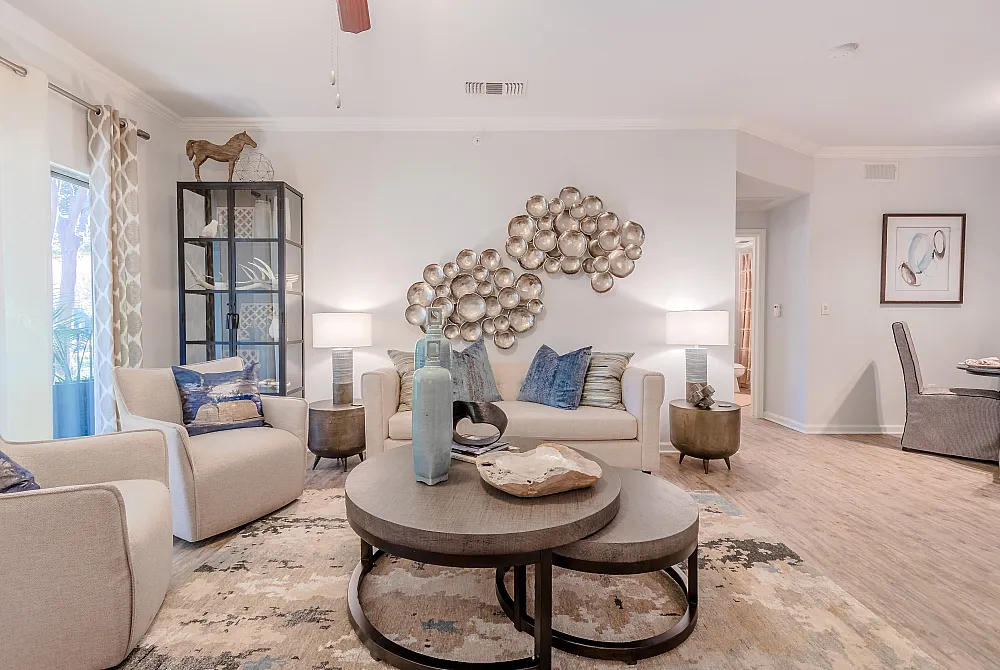 Elegant living room with stylish decor, plush seating, modern art, and a chic glass cabinet, exuding cozy sophistication.