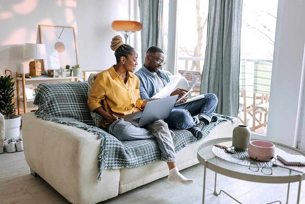 Bright and cozy living room with a modern sofa, stylish decor, and a peaceful balcony view, perfect for relaxation and home office space.